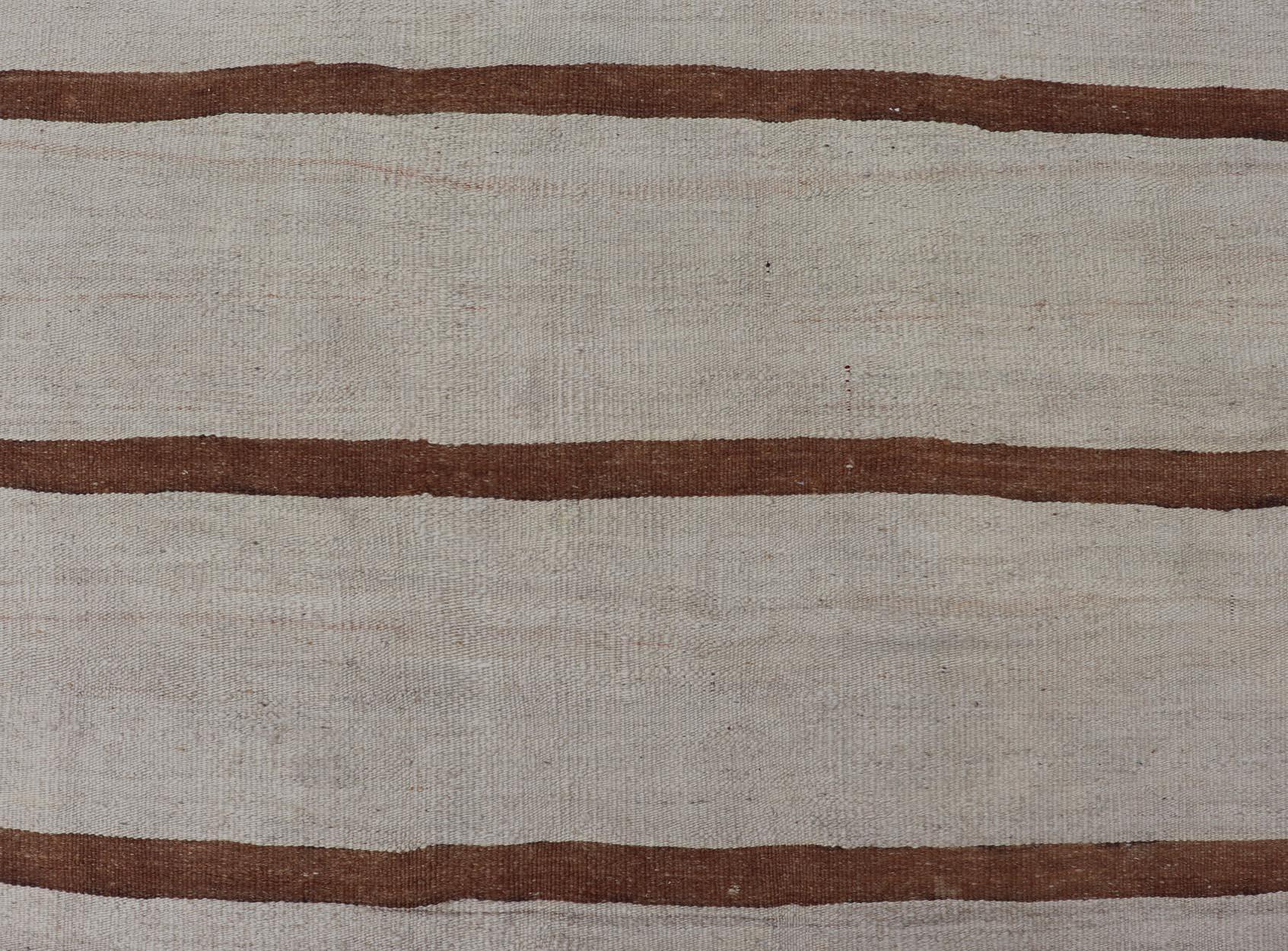 Vintage Turkish Flat-Weave Muted Colored Kilim in Elfenbein, Braun und Hellbraun. Minimalistischer Design-Kilim aus der Türkei, Teppich EN-14585, Herkunftsland / Typ: Türkei / Kelim, um 1950
Maße: 4'8 x 7'8 
Dieser flachgewebte Kelim im Vintage-Stil