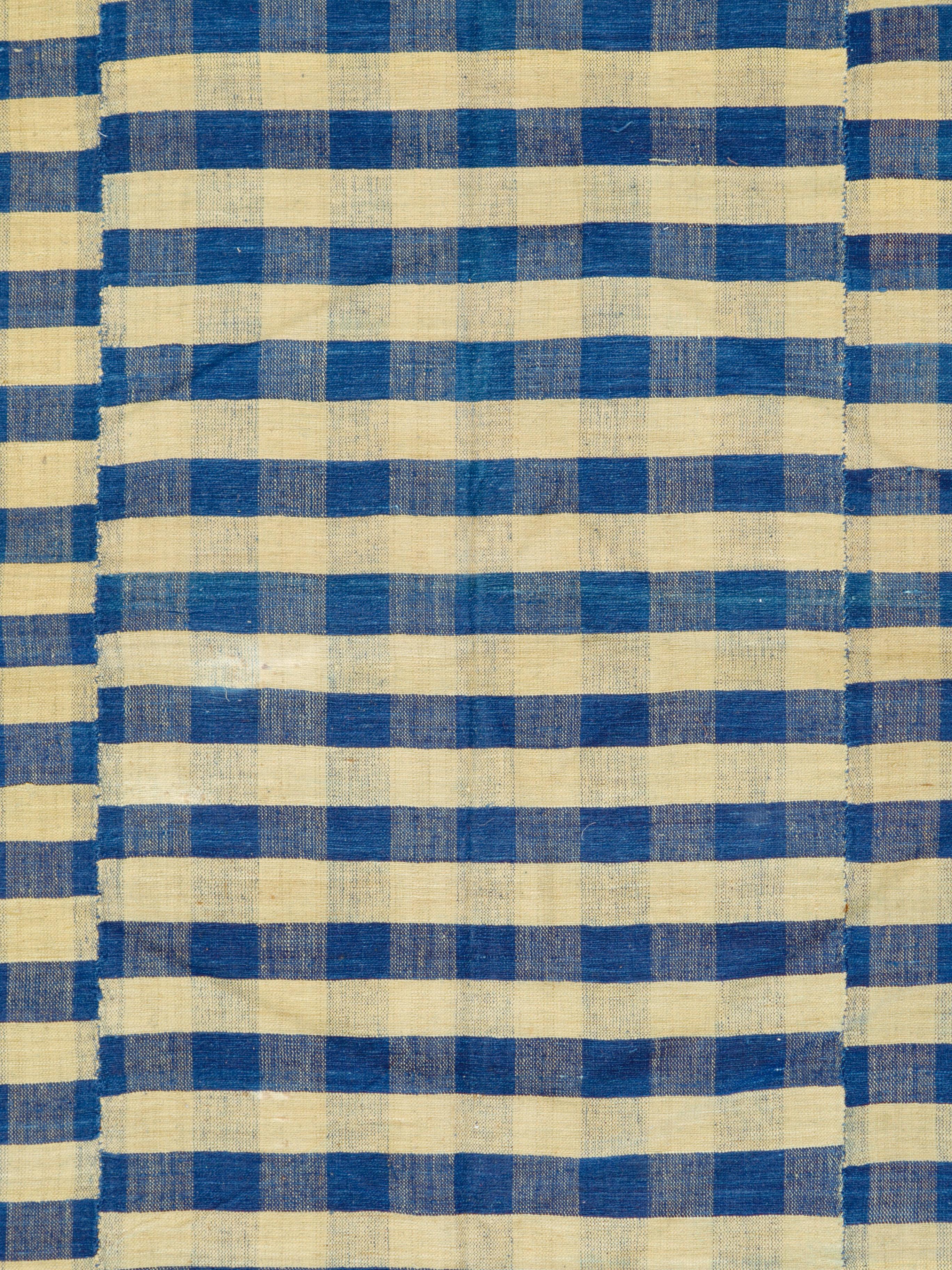 A vintage Turkish flat-woven Kilim rug from the mid-20th century. Three identical, yet stepped, panels create a very bold blue and yellow plaid design. The perfect coffee table piece for an urban apartment; the bold design will work very well in a