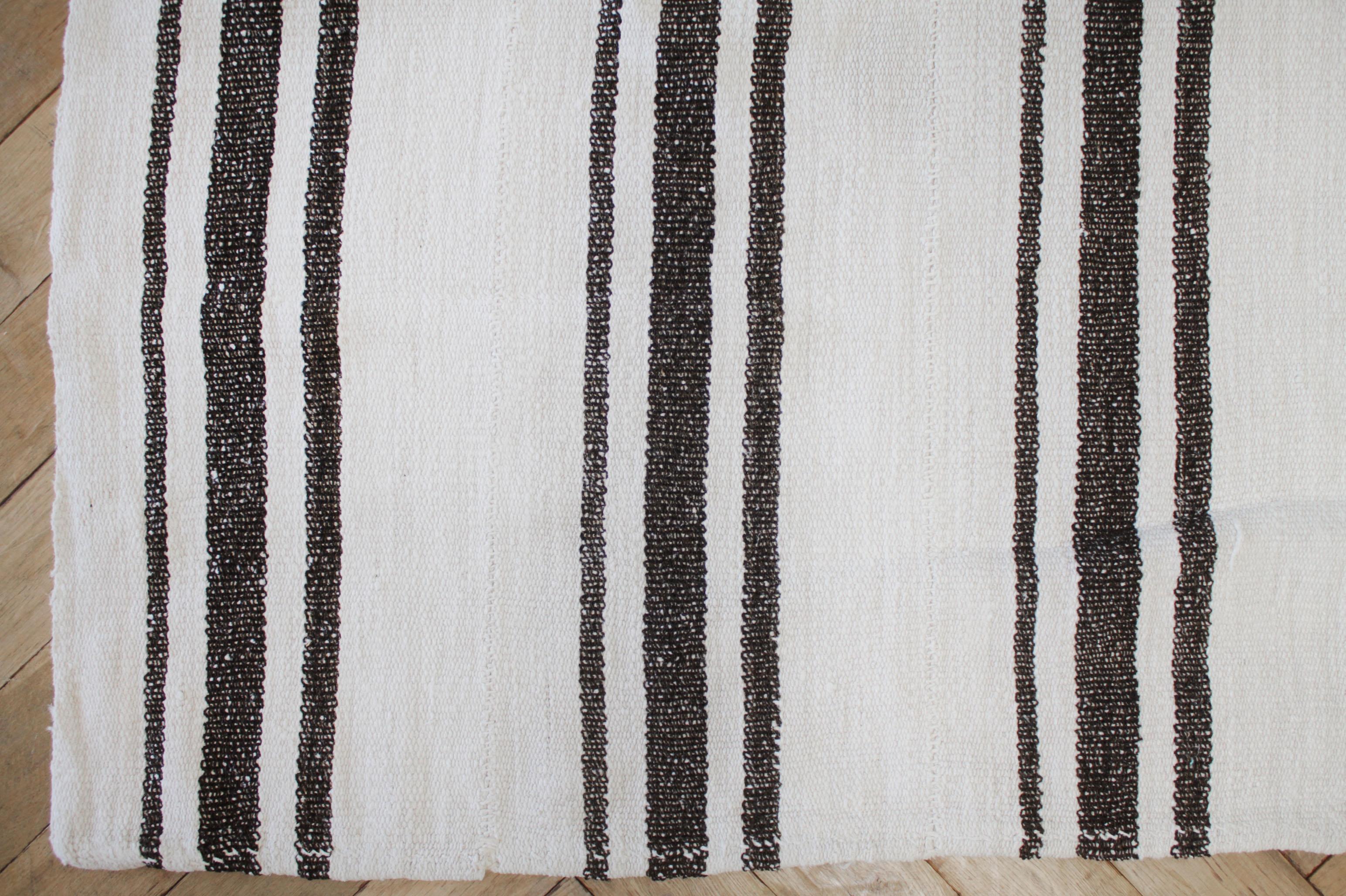 Samteppich
Türkischer Vintage-Teppich aus austerweißem Hanf mit dunkelbraunen Streifen.
Das flache Hanfgewebe macht sie extrem haltbar und eignet sich hervorragend für stark frequentierte Bereiche. Dieser Artikel wurde gereinigt und ist