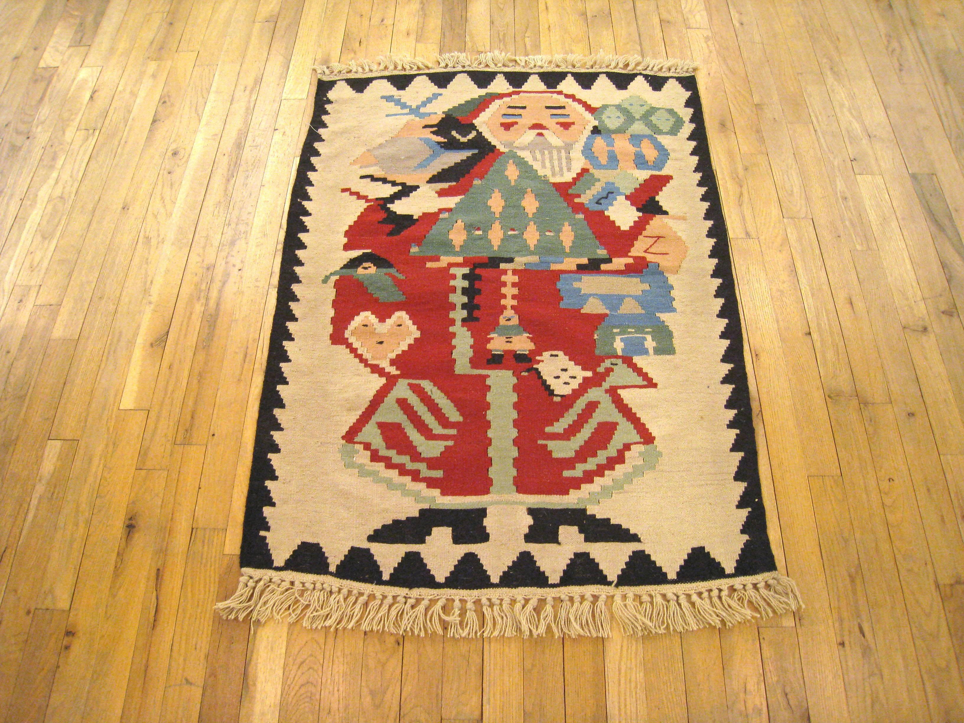 A vintage Turkish Kilim flat-woven rug, circa 1940-1950, size: 3'9 H x 2'9 W. This unique handwoven wool rug, which is a flat-weave with no upward pile, is characterized by a stylized Baba Noel (Santa Claus) design, with several smaller birds and