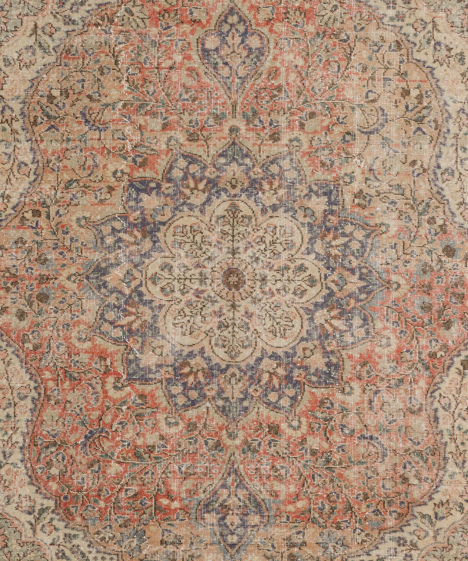 A vintage hand knotted Turkish rug from the 1960s with a distressed look, featuring an ornate design of meandering leafy vines and flower heads all-over the field with notable tulip motifs in the spandrels all surrounding a similarly ornate central