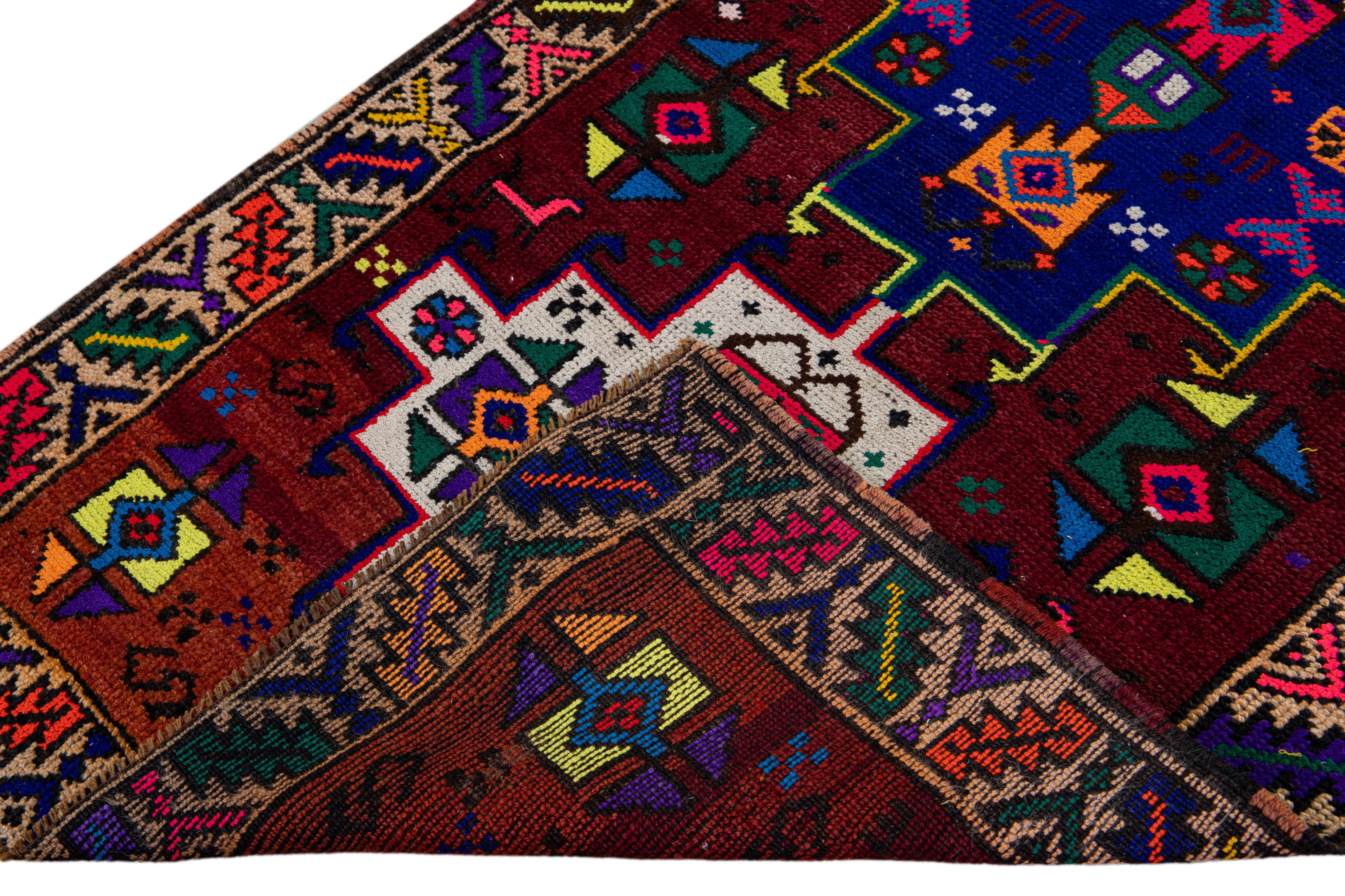 Beautiful vintage Turkish hand-knotted wool rug with a burgundy field. This rug has a tan designed frame and multicolor accents in a gorgeous all-over geometric tribal design.

This rug measures: 3' x 12'10