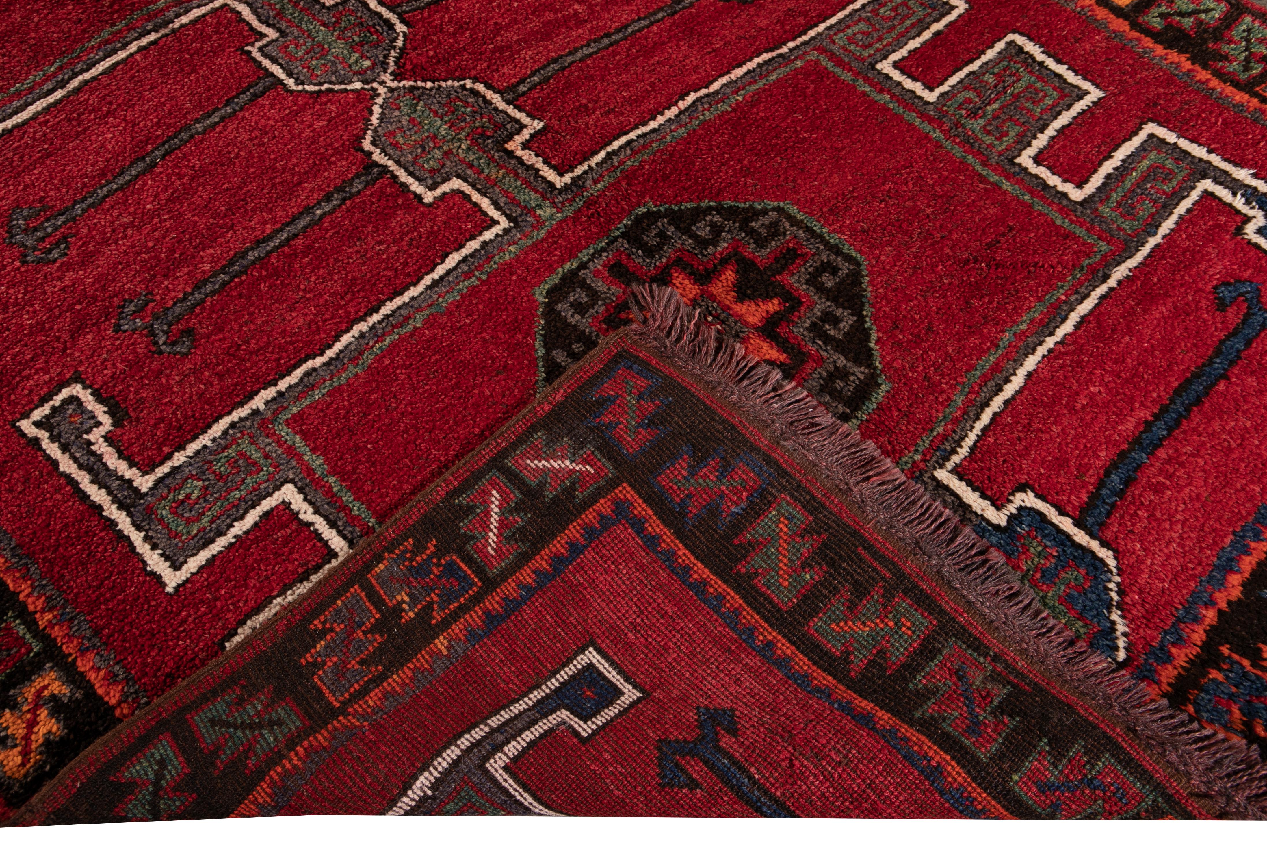 Beautiful vintage Turkish hand-knotted wool rug with a red field. This Turkish rug has a brown frame and navy-blue, orange, white, and gray accents in a gorgeous all-over geometric Tribal design.

This rug measures: 6'1