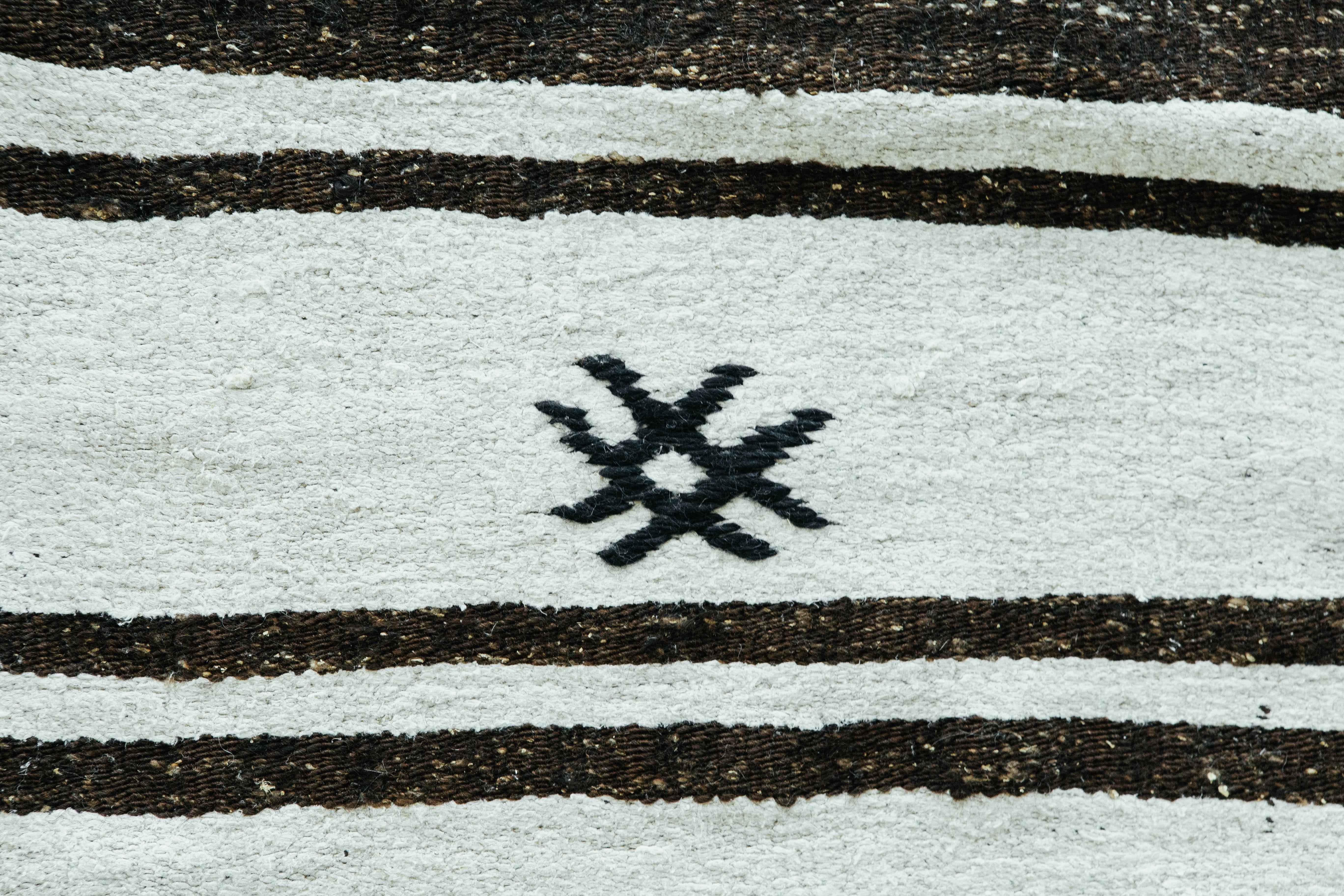A beautiful brown and white striped vintage Turkish Kilim. This this piece is made of hemp which creates a very interesting texture that is both durable and easy to design around. Sporadic tribal motifs create a unique and curious essence.


Rug