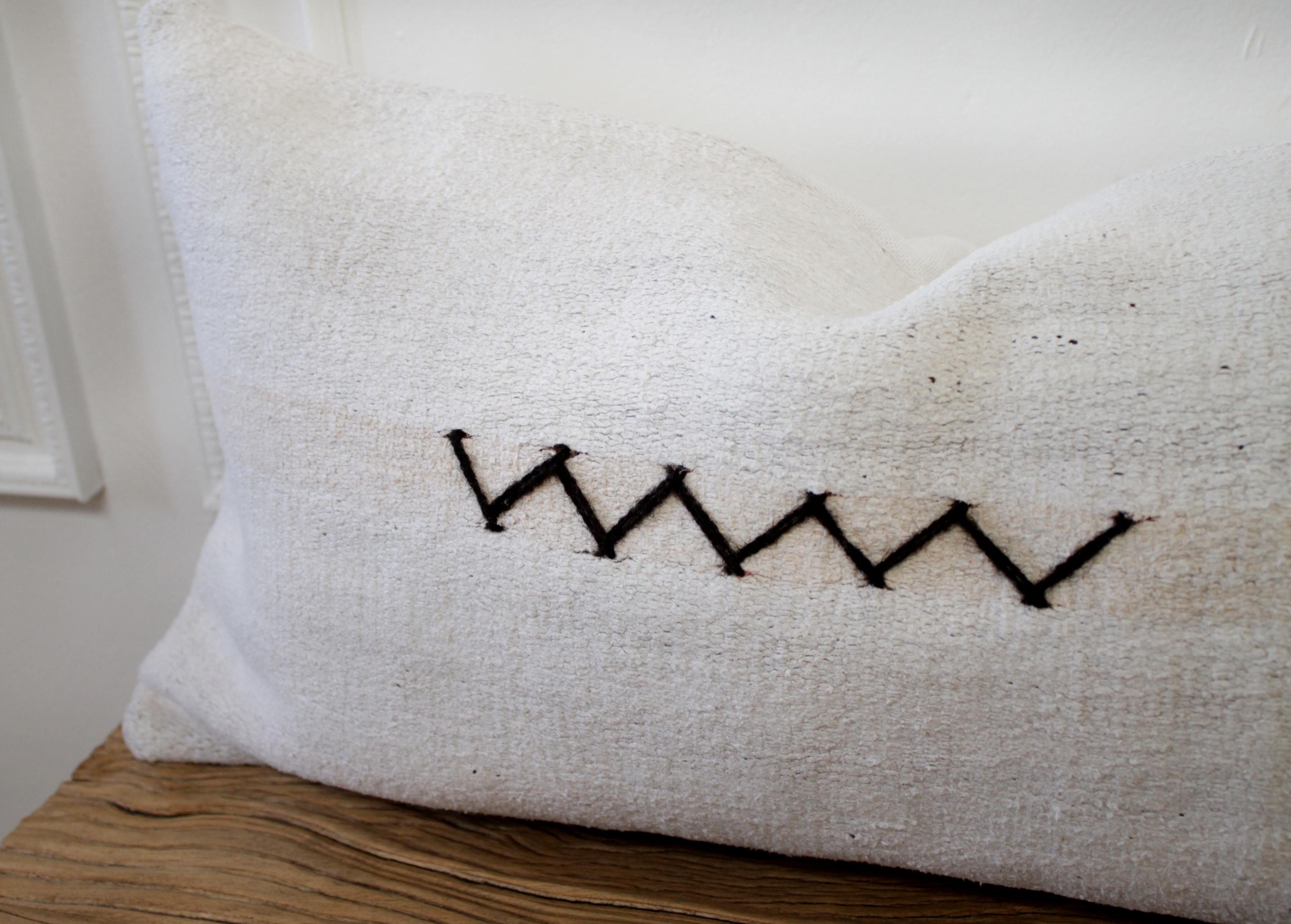 Vintage Turkish Hemp rug pillow in off-white with stitched pattern on face of the pillow. This is a beautiful original hemp rug, in a white to off white color with goat hair textured Minimalist zig zag pattern. The backside is a coordinating fabric