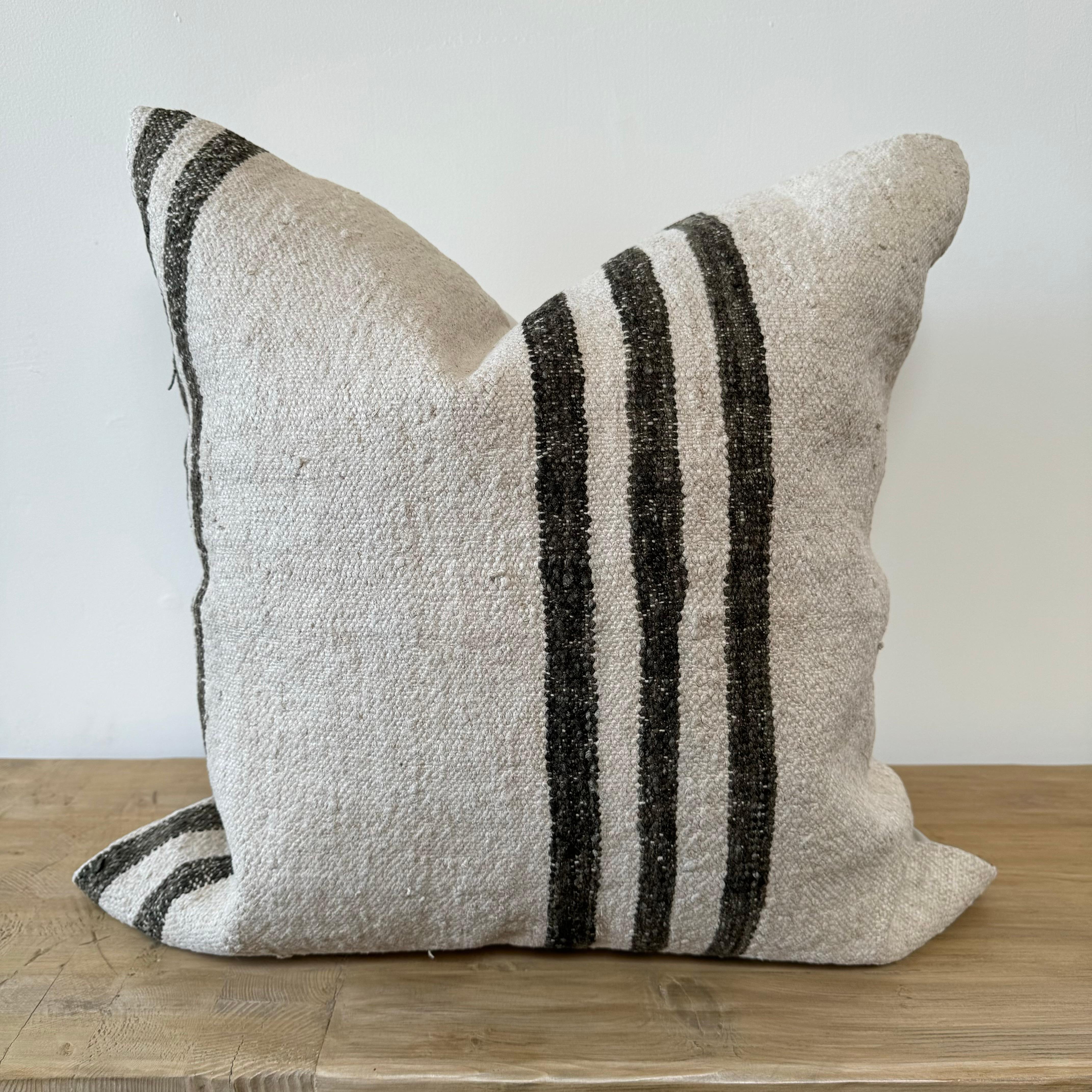 Creamy white hemp rug pillow with brown stripes. 
Soft hand, cotton backing with zipper closure
Includes down/feather insert.
Spot cleaning is recommended, or dry clean. These rugs have been professionally cleaned prior to construction. These