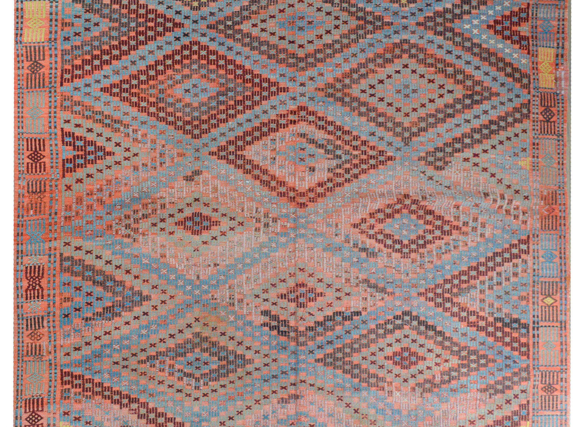 A beautiful vintage Turkish flat-weave Kilim with a fantastic all-over geometric pattern woven with myriad tiny X's forming a larger diamond pattern, and woven in myriad colors including crimson, indigo, green, gold, and black, against a crimson