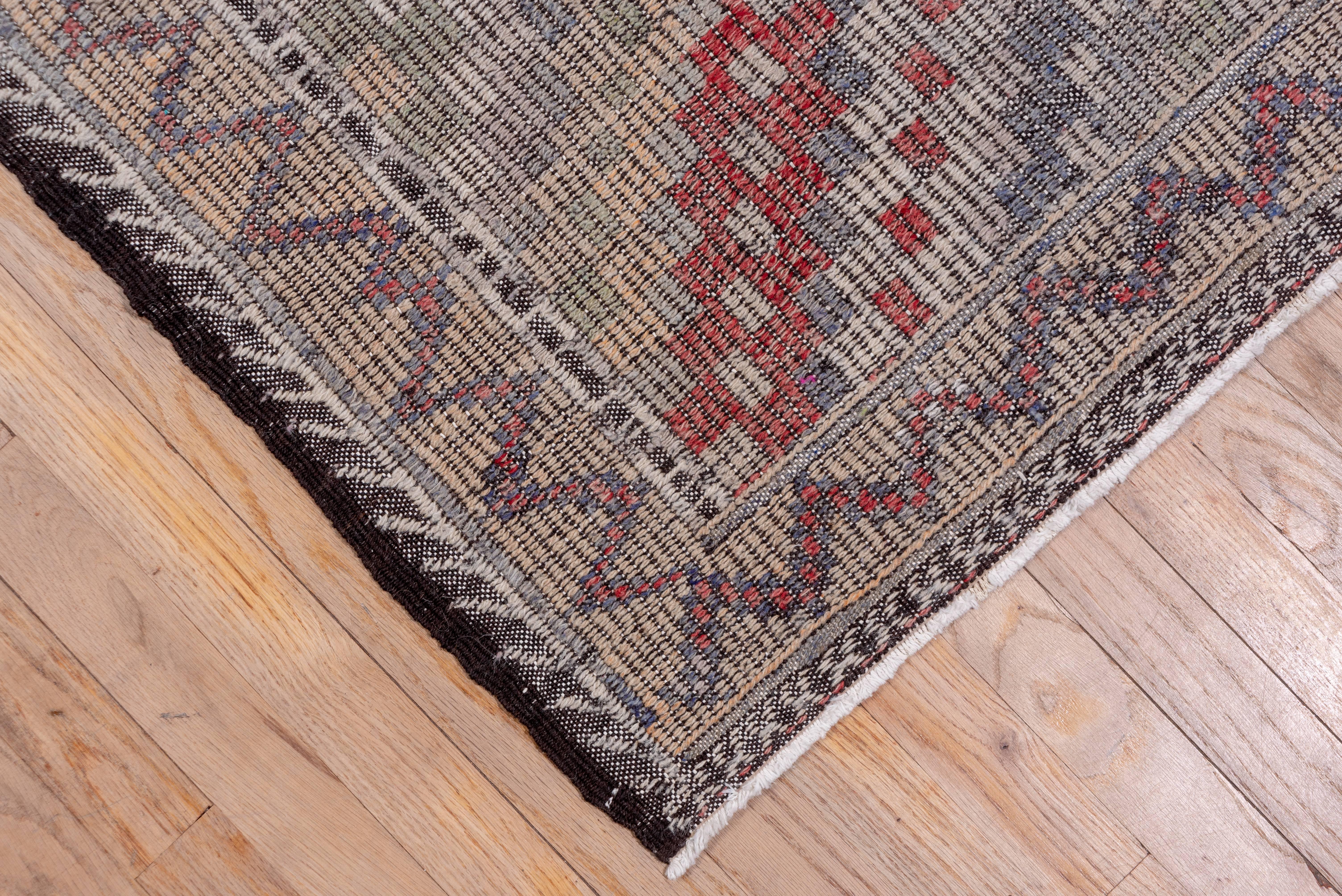 A bold stepped and nested  lozenge lattice pattern in which the diagonals  are composed  of small colored squares  decorates this softly toned eastern Turkish flat weave in the weft float technique on a dark brown ground fabric. The condition is