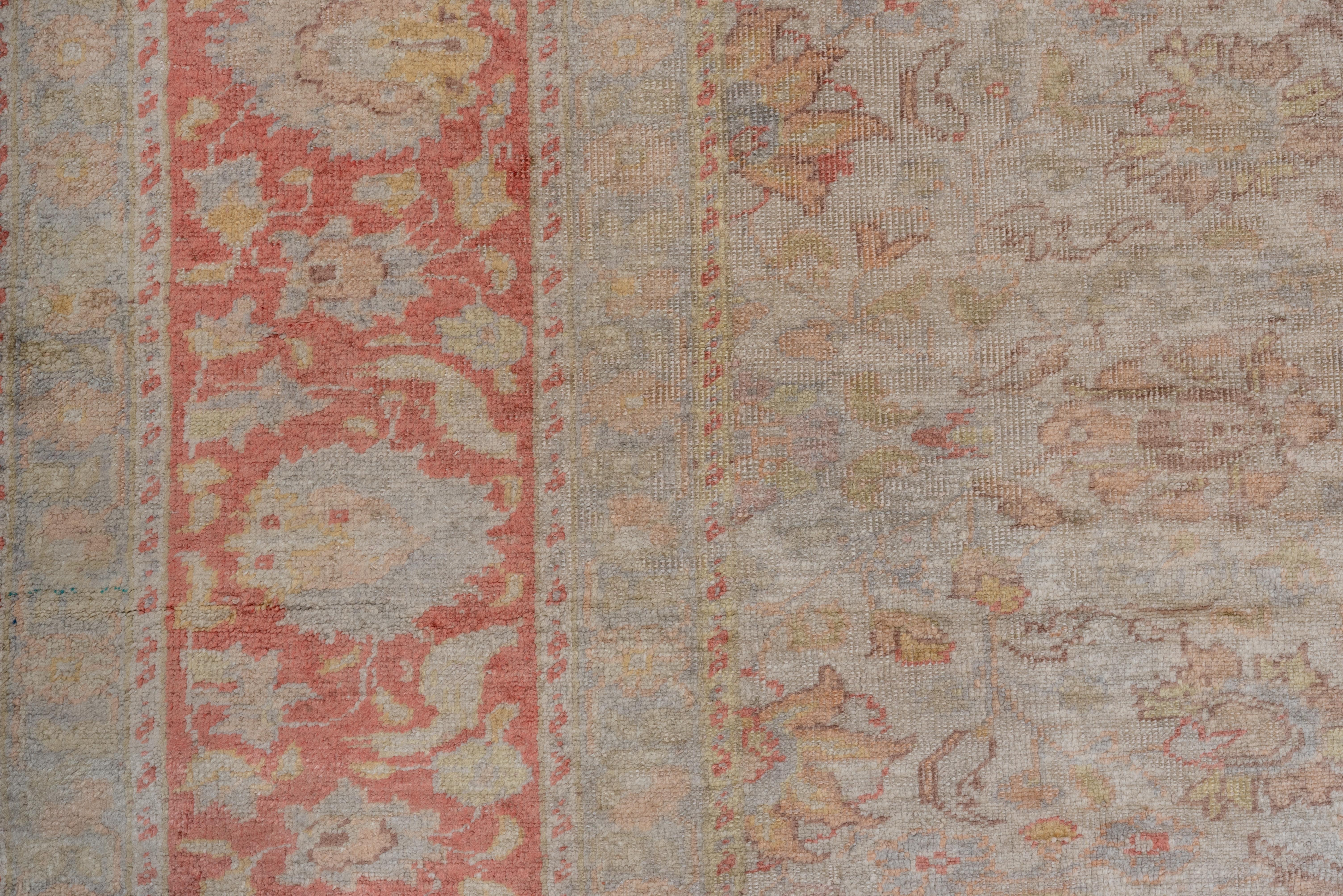 Dieser mäßig gewebte osttürkische Teppich zeigt ein offenes Allover-Muster aus Rosetten, ovalen Palmetten und stilisierten Blättern, akzentuiert in Strohgelb, Grün und Braun, auf einem beige-cremefarbenen Grund. Korallenbordüre mit einfachen