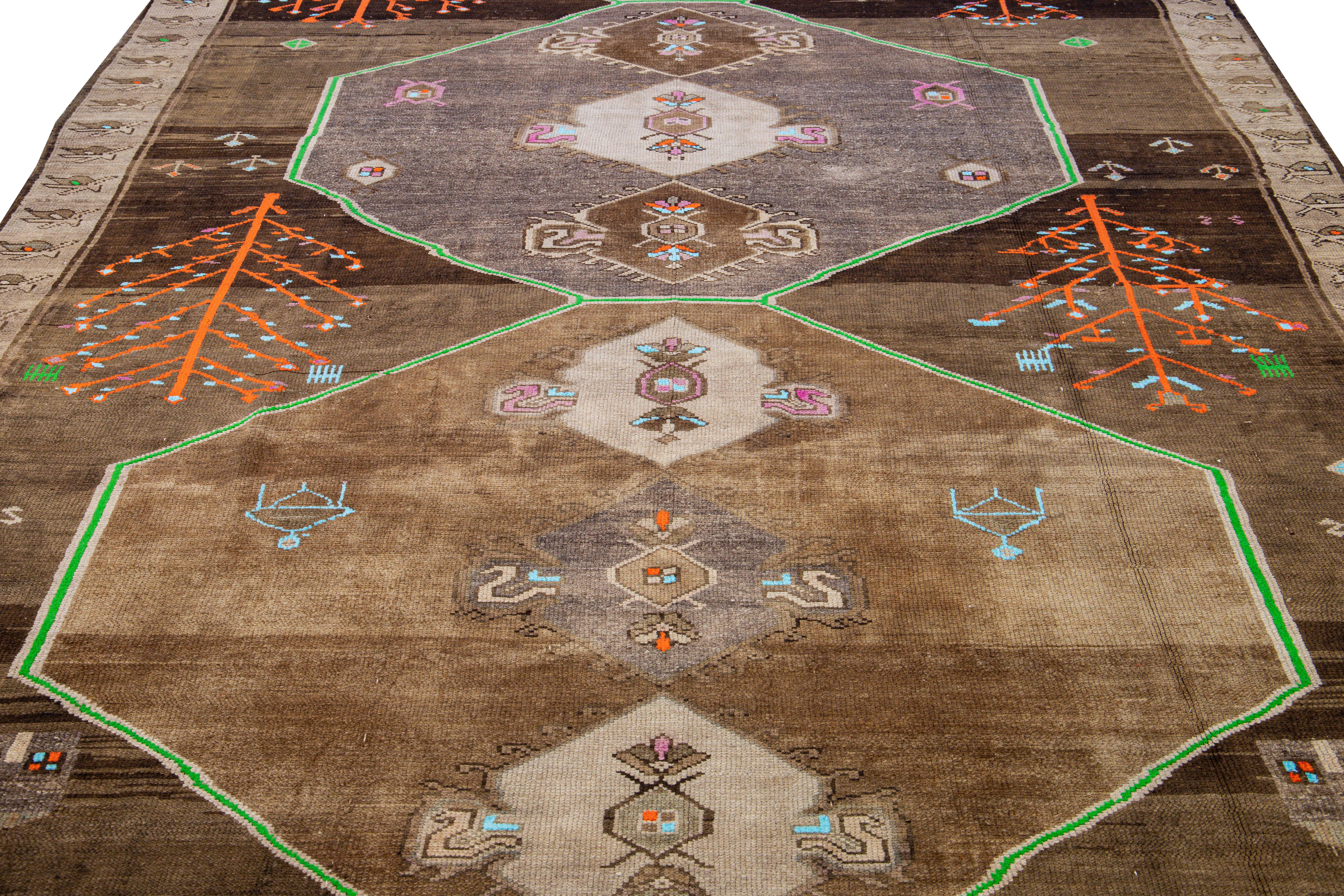 Beautiful vintage Turkish Kars hand-knotted wool rug with a brown field. This Turkish rug has green, orange, blue, and pink accents in a gorgeous all-over geometric Tribal design.

This rug measures: 8' x 13'1
