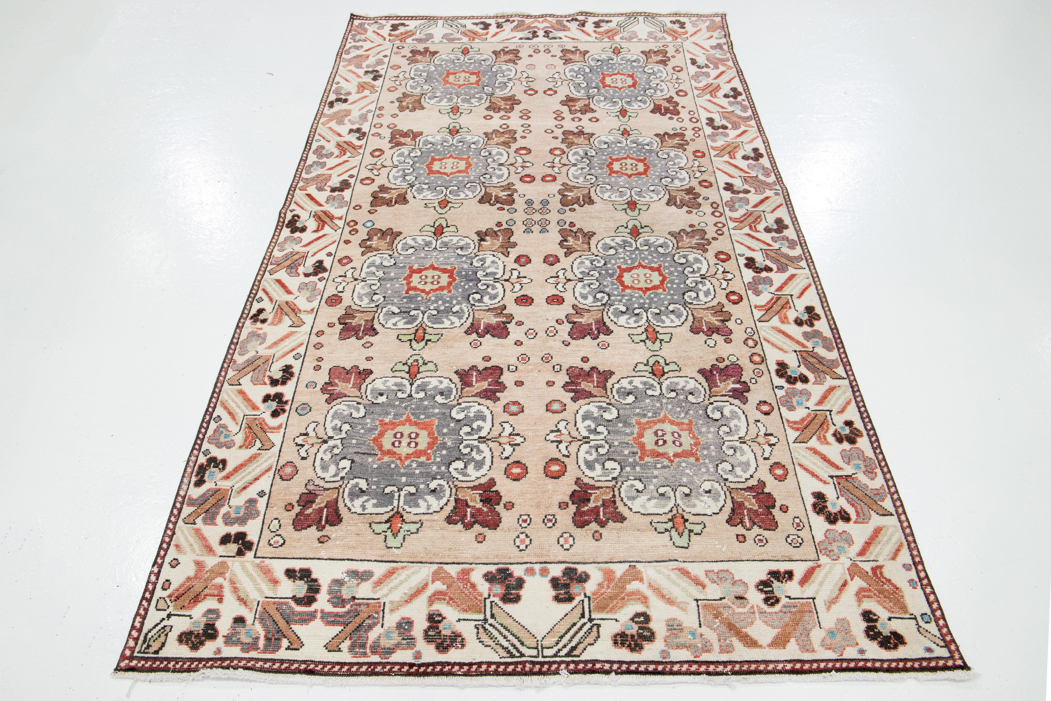 Dies ist eine schöne Vintage türkischen Kars handgeknüpfte Wolle Teppich mit einem Pfirsich Feld. Es zeigt blaue, terrakottafarbene, braune und graue Akzente in einem atemberaubenden floralen Muster.

Dieser Teppich misst 4'10