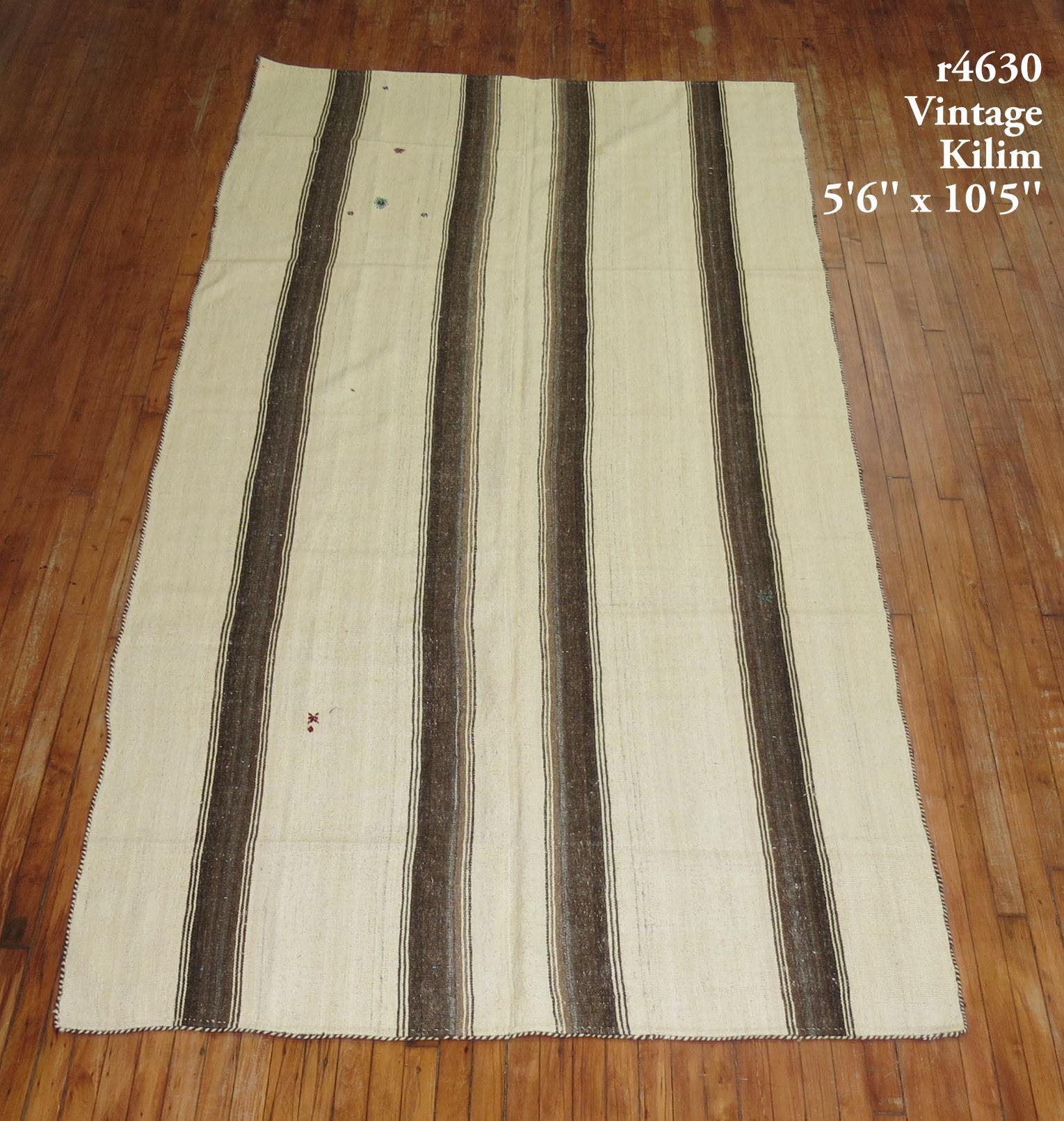 A vintage Turkish kilim with a striped motif in browns and cream.