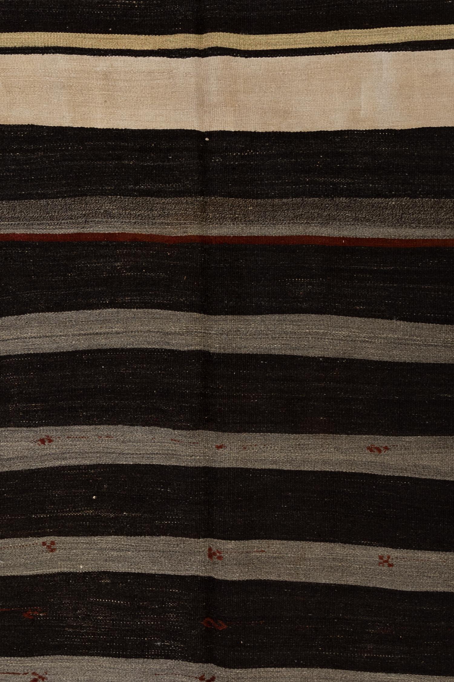 Age: Circa 1950

Colors: Washed black, alabaster, stone gray, sandstone, burgundy. 

Pile: Flatweave

Wear Notes: 2

Material: Hemp, wool.

Moody traditional striped hemp Kilim. The inclusion of ribbon and evil eye symbols are said to represent good