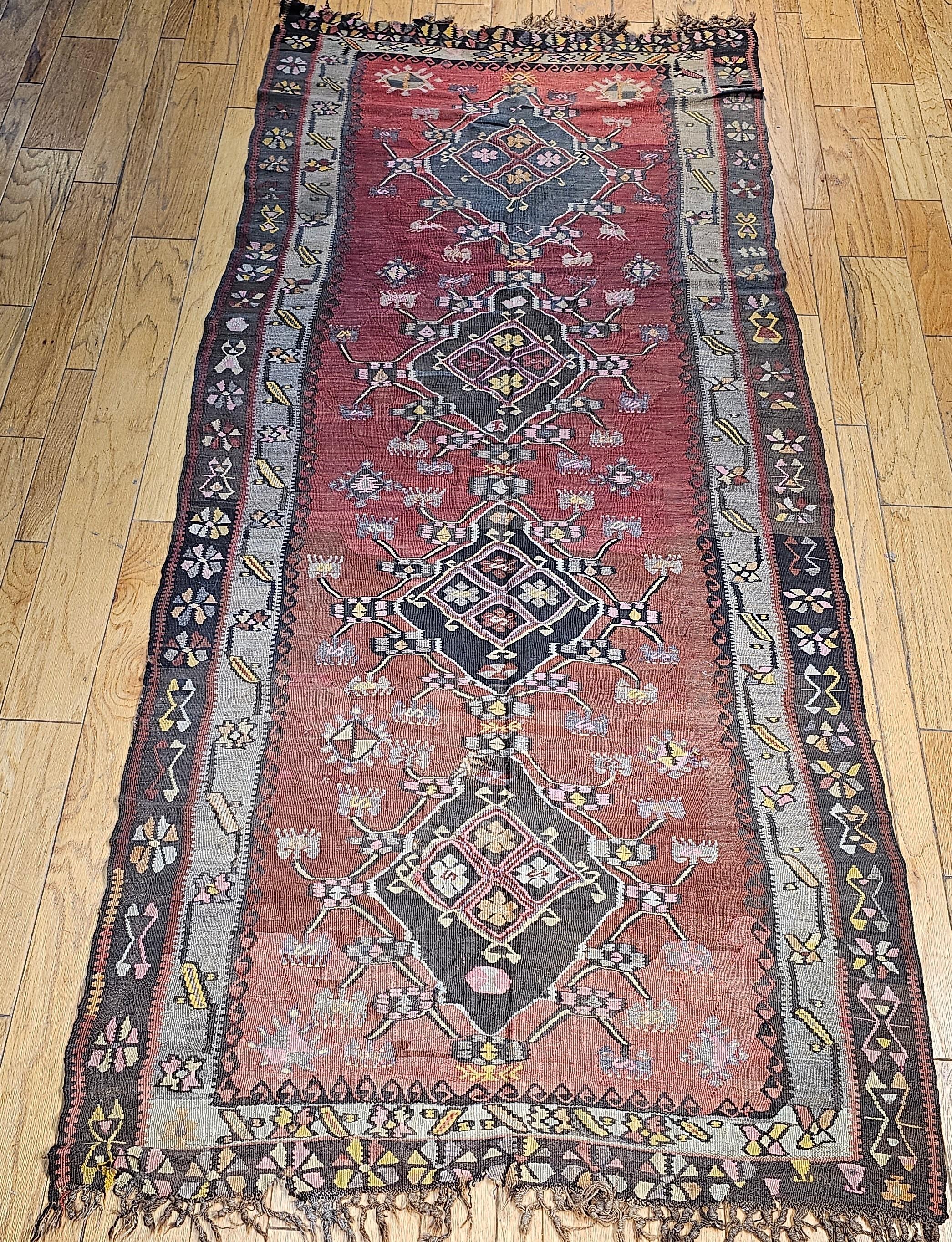 Beautiful vintage Turkish kilim from Eastern Turkey in a multiple medallion pattern from the early 1900s. This Turkish Kilim has four-diamond shaped medallions in a column in the center of the kilim.  The beautiful design is enhanced by the abrash