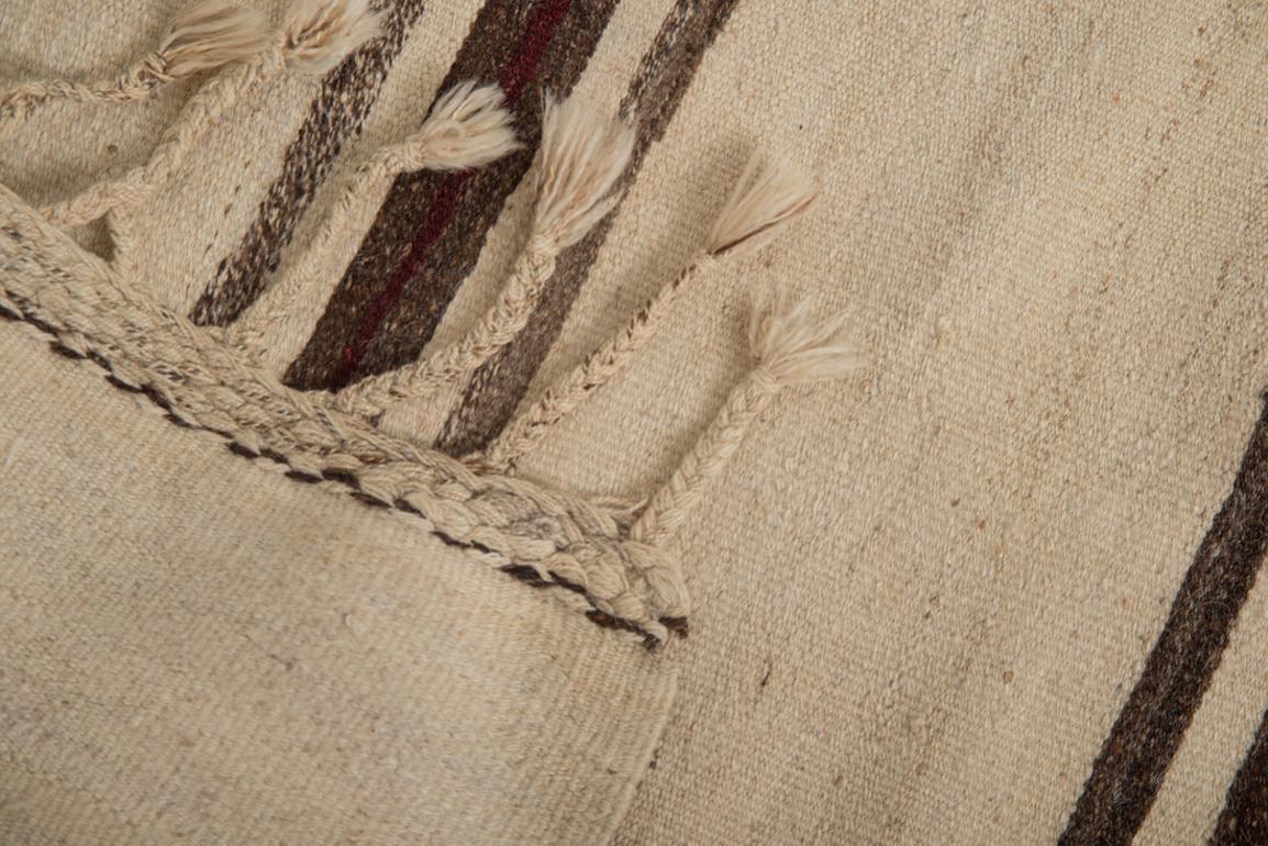 This vintage Kilim was handwoven in the east part region of Turkey. 
These flat-weaves with their horizontal lines and hefty texture are very rare nowadays, making them very special tribal rugs.
It is remarkable that something with such a rich