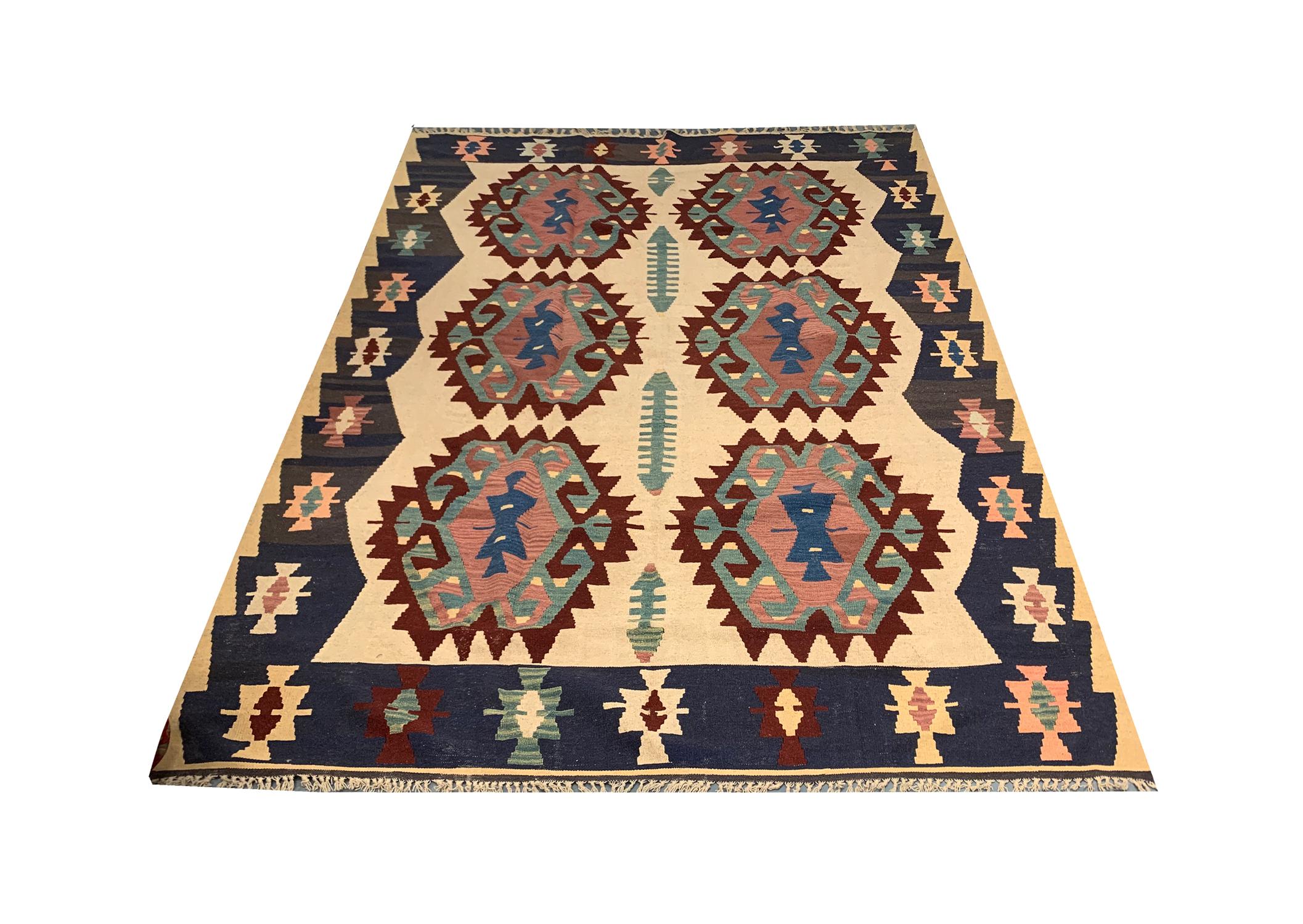 This elegant handwoven wool Kilim area rug was constructed in the late 20th century around 1980 in Turkey. The design features cream, brown, and blue colours that make up the fantastic elegant design. Both the colour and design in this piece are