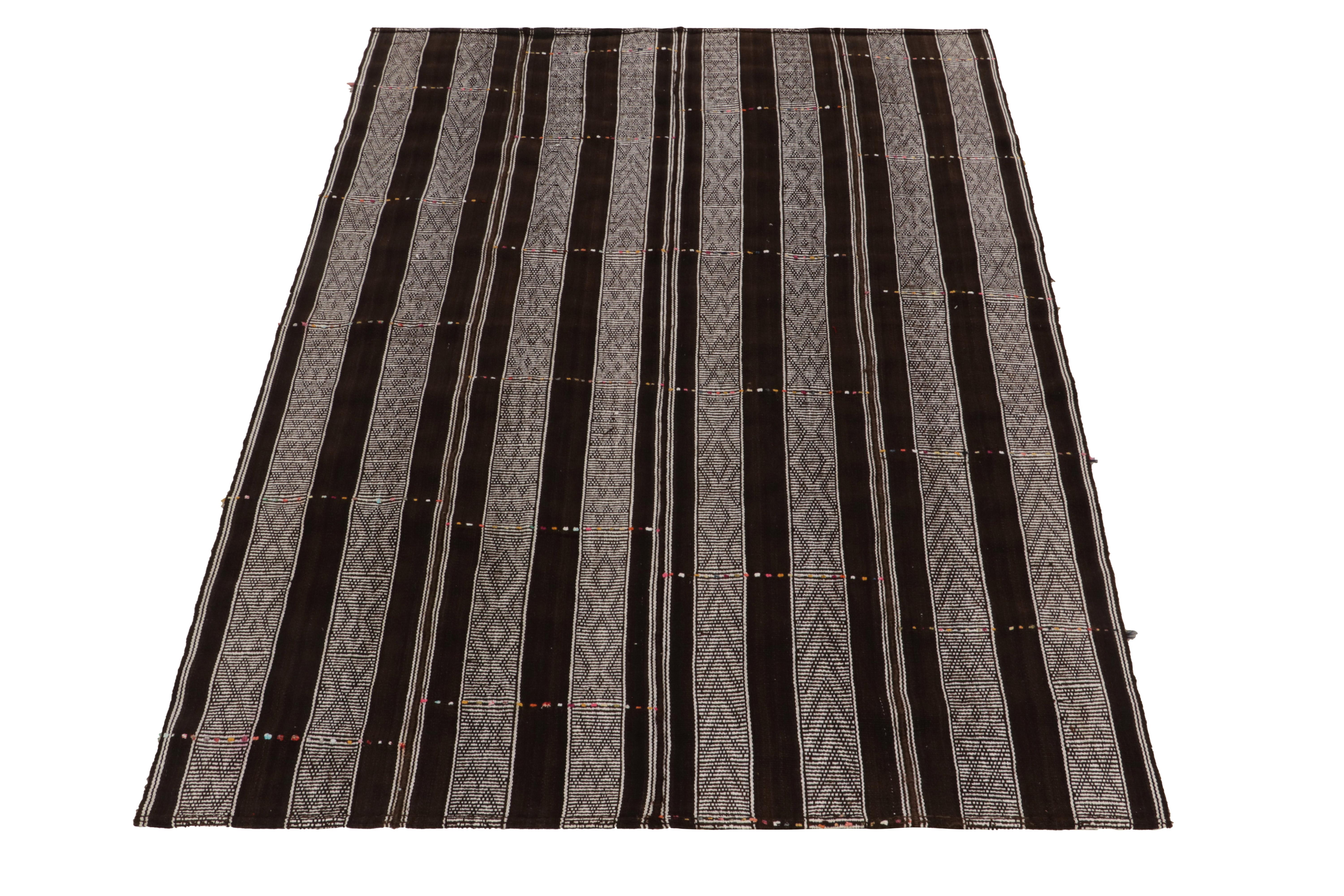 Vintage Turkish Kilim rug in all over Brown, Black & White striped pattern
Description: Handwoven in wool, a vintage Turkish kilim rug circa 1950-1970 exhibiting textura stripes in brown-black and white with exemplary pagination in mid century