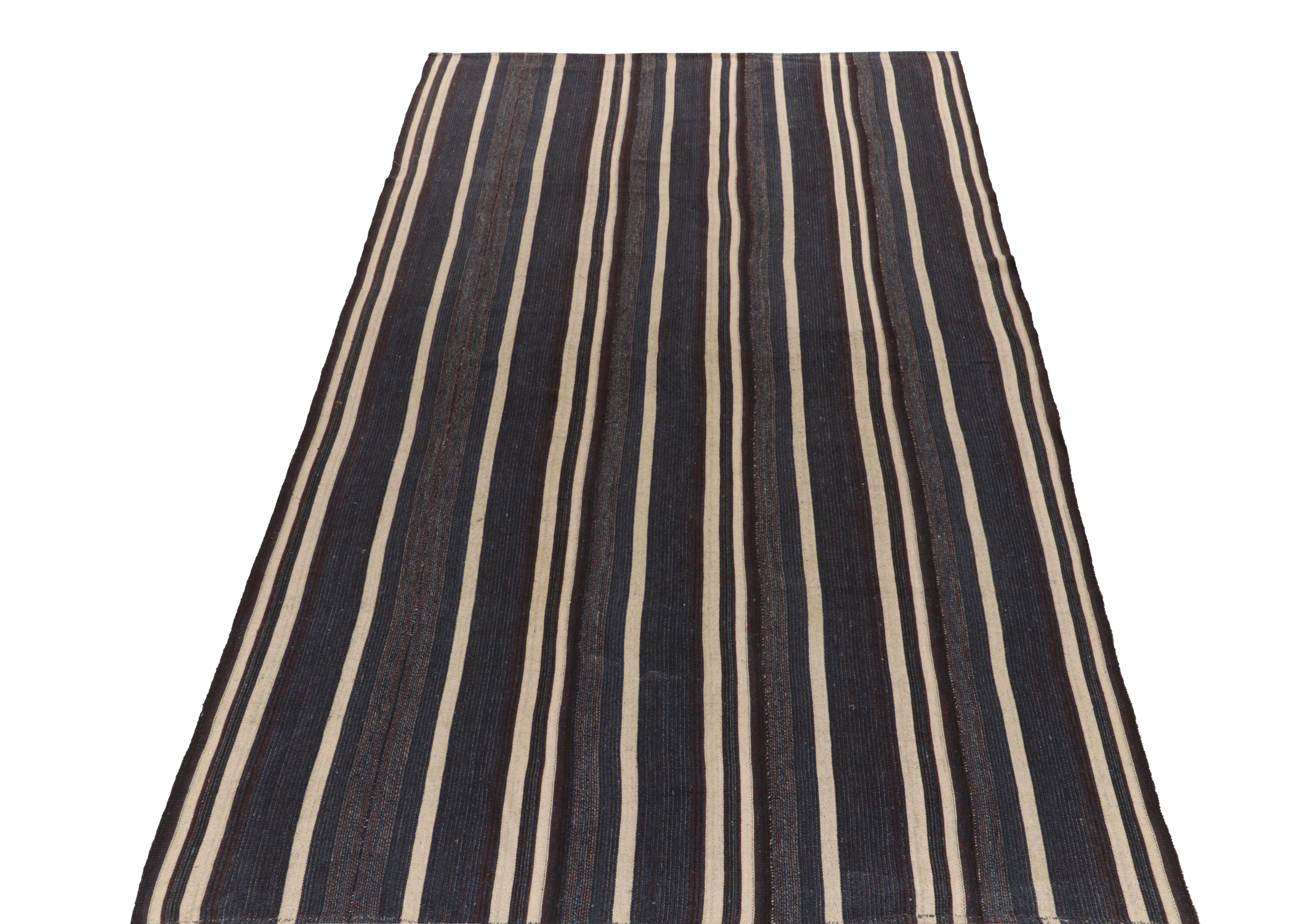 Handwoven in panel style, a 7x12 vintage Turkish kilim rug from our flatweave selections. The unique weave casts an elegant impression with striations in a rare blue and off-white colorplay accenting to subtle purples & complementary tones hinting