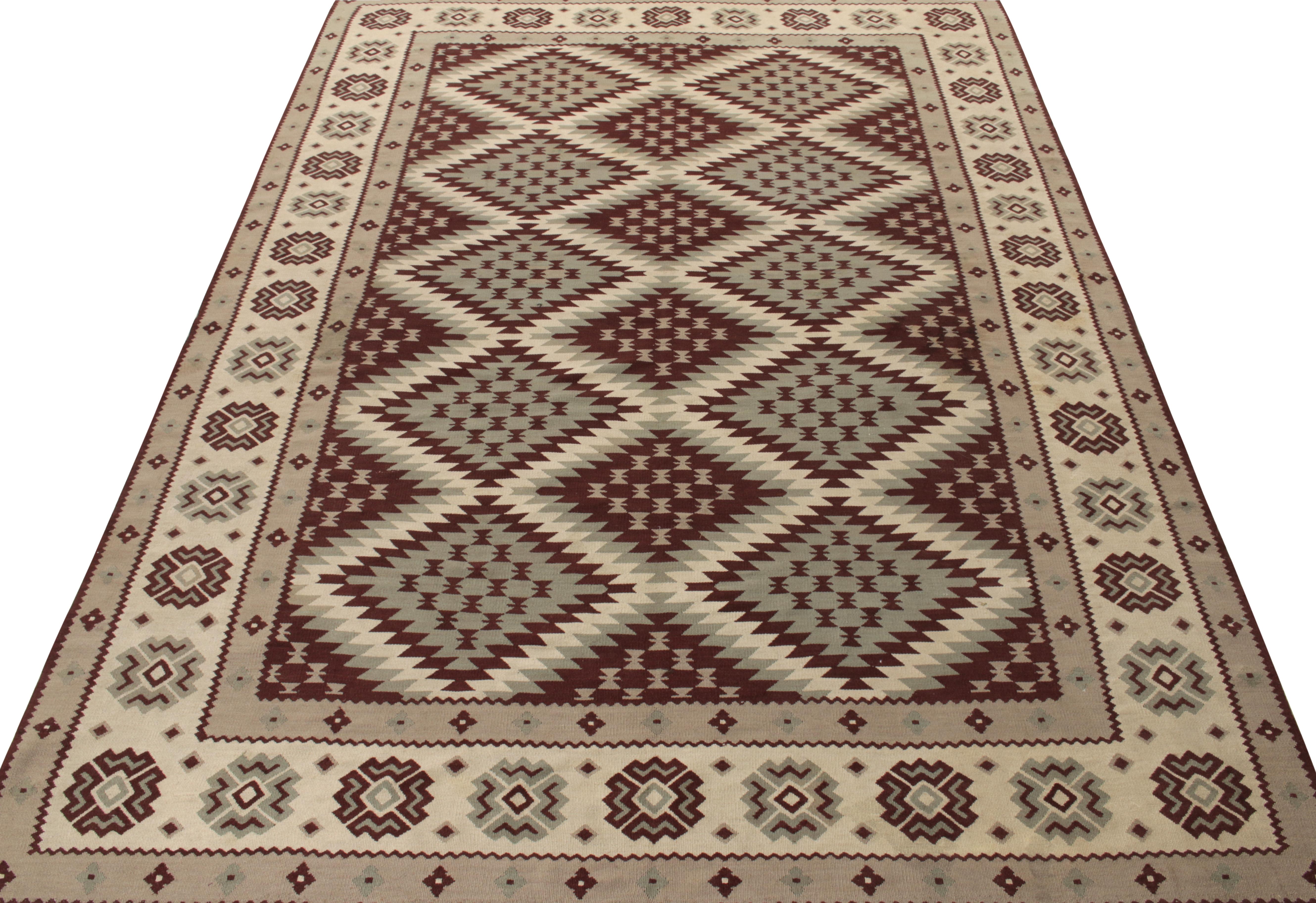 Dieser scharfe Kelimteppich aus der Türkei (ca. 1950-1960) zeigt ein ordentliches geometrisches Muster mit Stammesmotiven in Lavagrau, cremefarbenem Off-White und reifen braunen Akzenten. Ein 6x9-Sammlerstück mit balkanischem Einfluss, das in