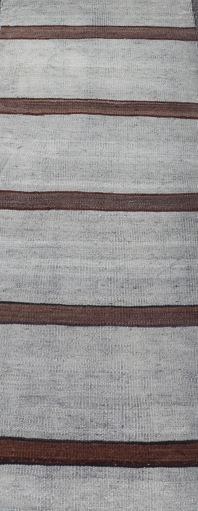 Misure: 1'8 x 4'5 

Questo squisito tappeto kilim turco vintage sfoggia un design senza tempo con le classiche strisce grigie e marroni. L'armoniosa miscela di toni grigi e marroni profondi crea un pezzo sofisticato e versatile, perfetto per