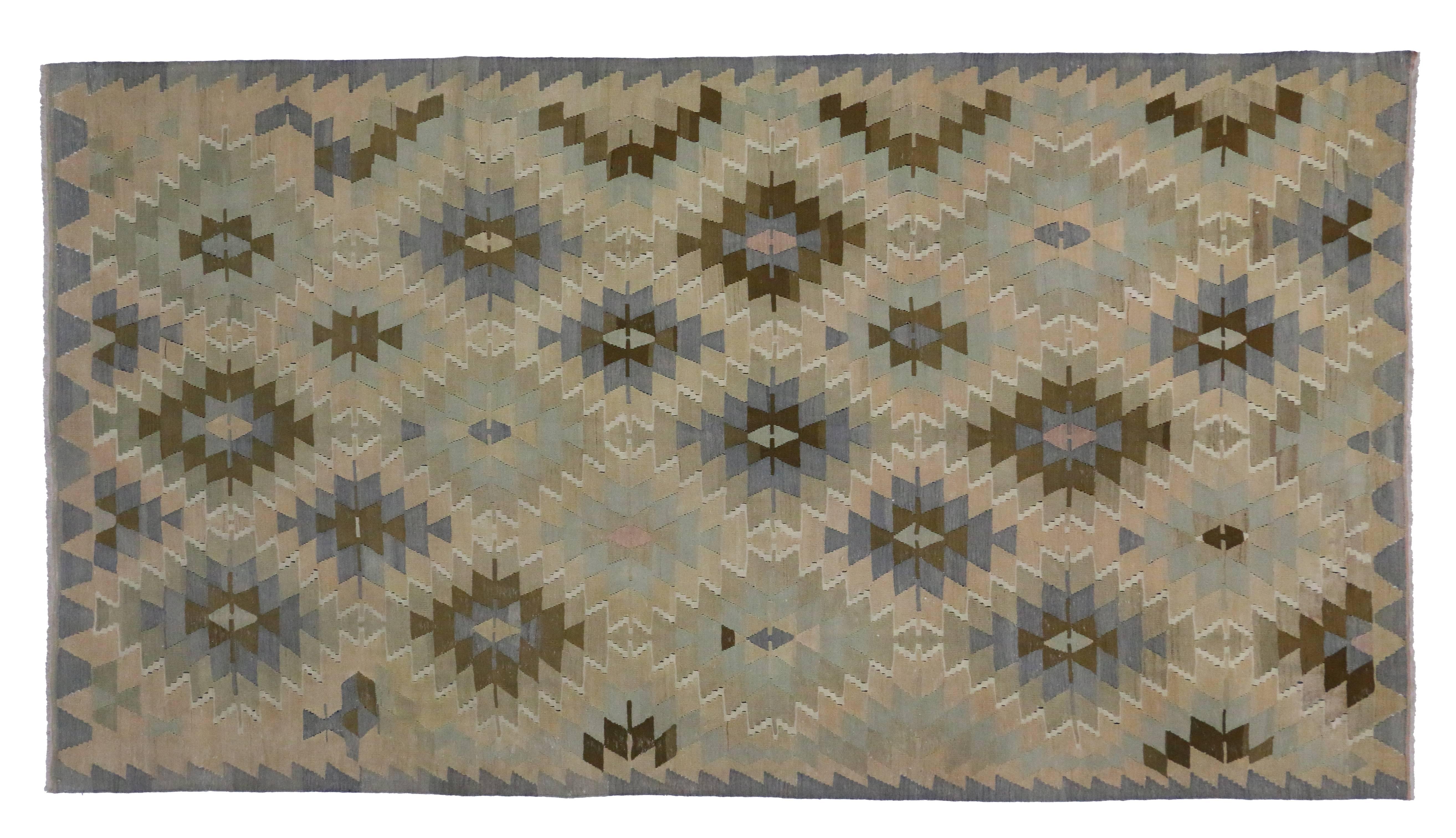 51235, vintage Turkish Kilim rug with southwestern-coastal chic style. This hand-woven wool vintage Turkish kilim rug features an all-over geometric motif of serrated diamonds filled with fused triangles. Rendered in variegated colors and cool