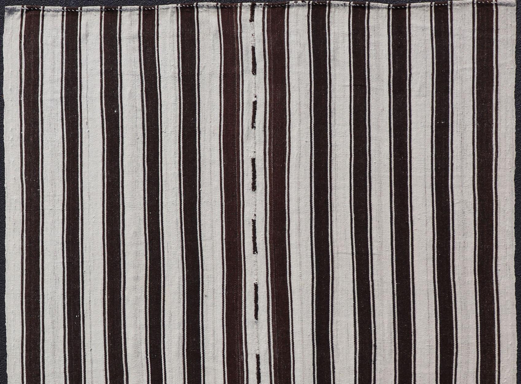 Flat-weave vintage Kilim vintage rug from Turkey with vertical stripes in dark brown and cream. Rug TU-NED-1123, country of origin / type: Turkey / Kilim, circa 1950

Woven during the mid-20th century in Turkey, this Kilim is decorated with a
