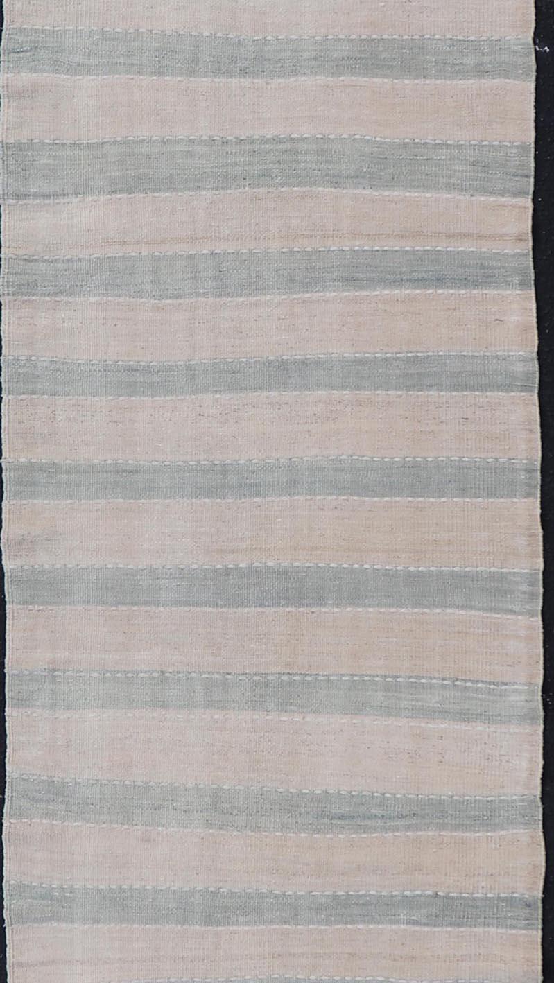 Mesures : 2'7 x 12'2 

Ce tapis Kilim turc vintage présente des couleurs claires et délavées dans un motif à rayures simple. Cette pièce vintage est intemporelle avec sa palette et son schéma simples, ce qui en fait une pièce parfaite pour les