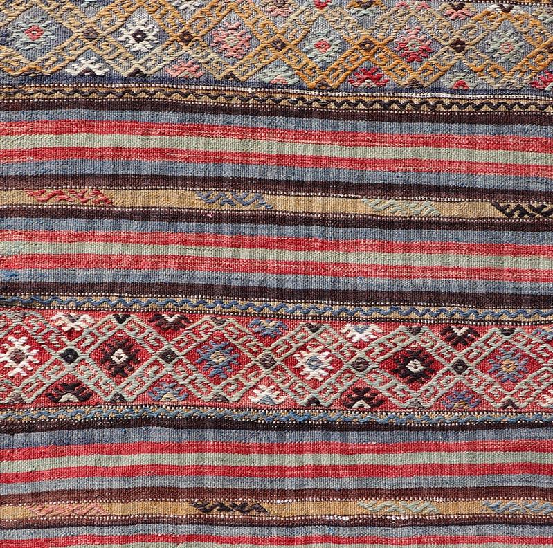 Vintage Turkish Kilim with Horizontal Stripes and Tribal Motifs in Bright Tones. Hand Woven vintage Turkish Kilim in colors, Keivan Woven Arts / rug TU-NED-5047, country of origin / type: Turkey / Kilim, circa Mid-20th Century.

Measures: 2.5 x 95.