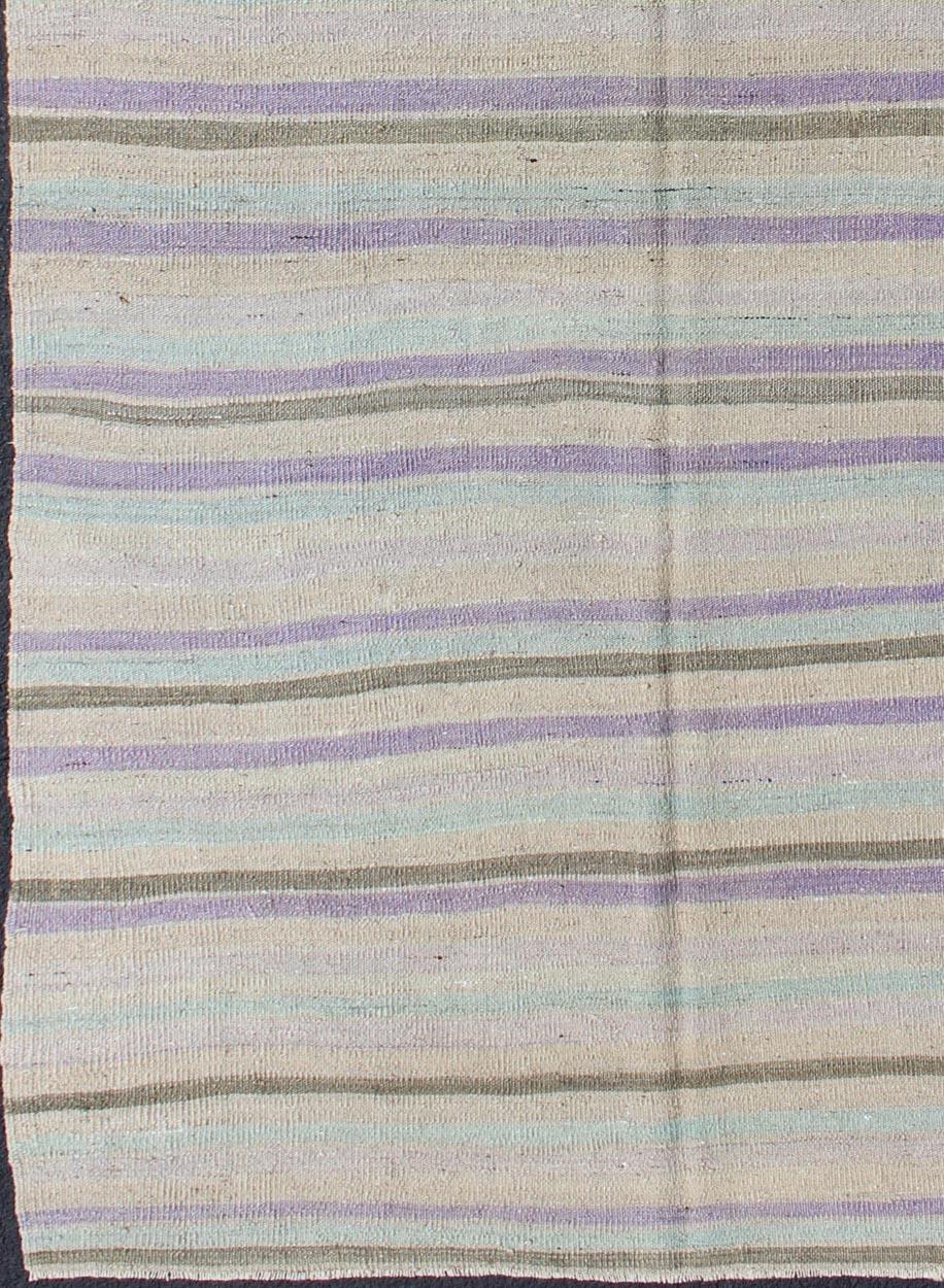 Vintage Turkish Kilim with Stripes in Light Teal, Pastel Purple, Cream and Taupe  rug/tu-mtu-95040  origin/turkey 

This vintage Kilim carpet from Mid-Century Turkey features a stripe pattern set atop an grey background. Colors include grey, taupe,