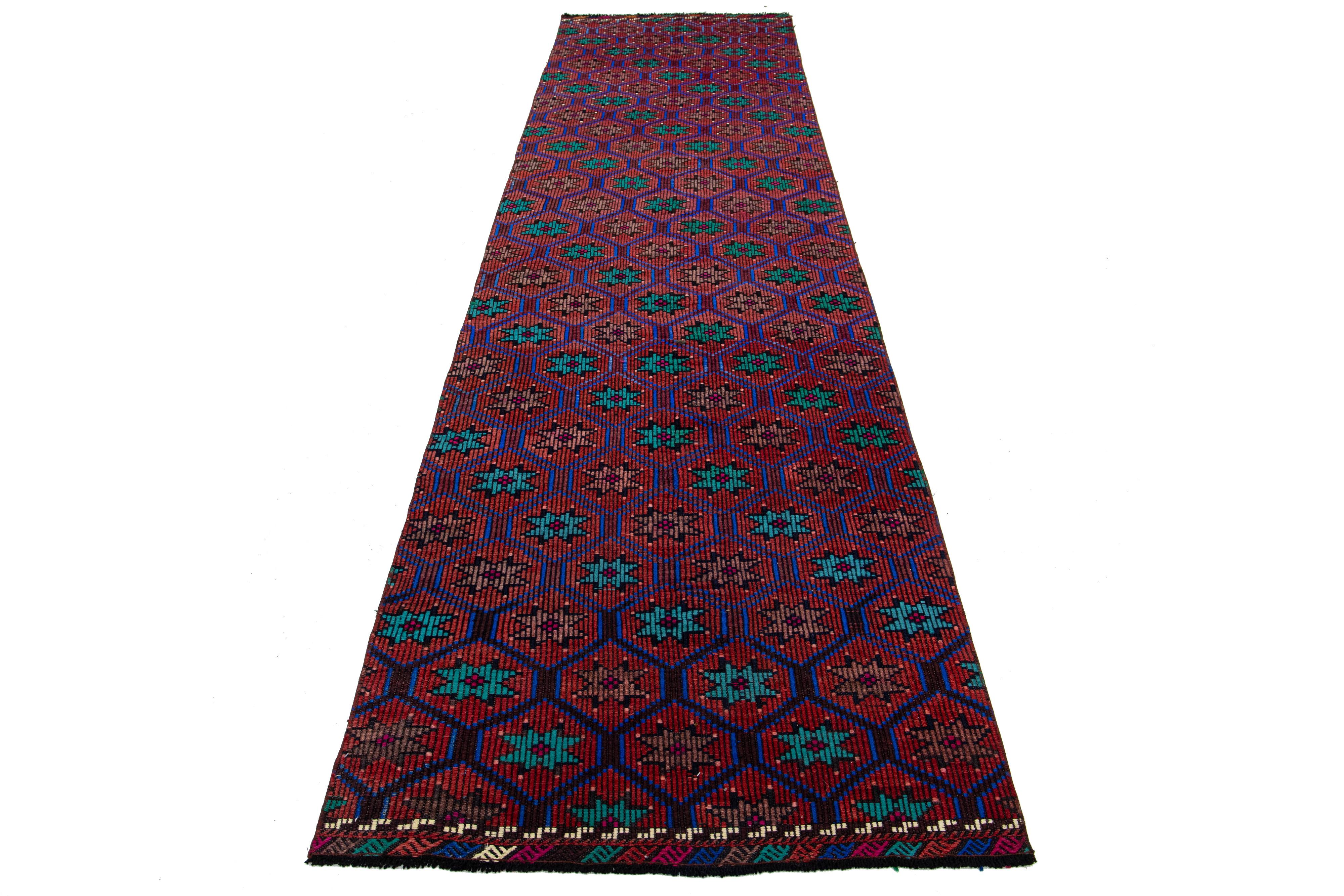Ce magnifique tapis kilim en laine présente un étonnant design géométrique sur tout le pourtour, avec des accents multicolores vibrants sur un fond rouille foncé.

Ce tapis mesure 3'2