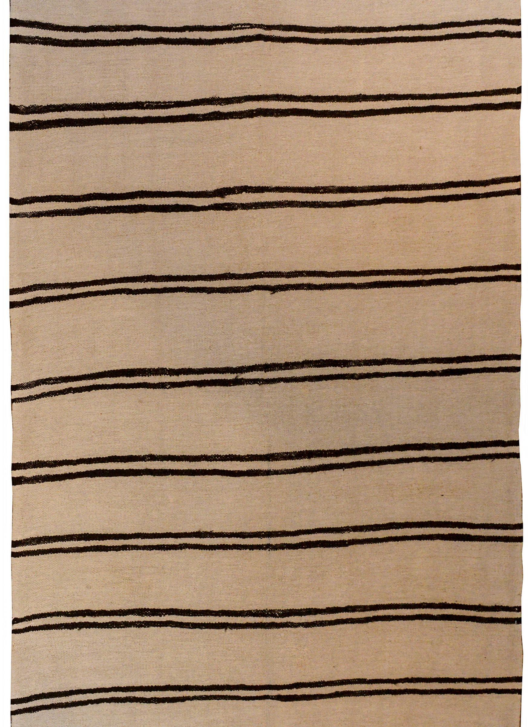 A vintage Turkish Konya handwoven cotton kilim rug with a cream field and multiple pairs of black stripes.