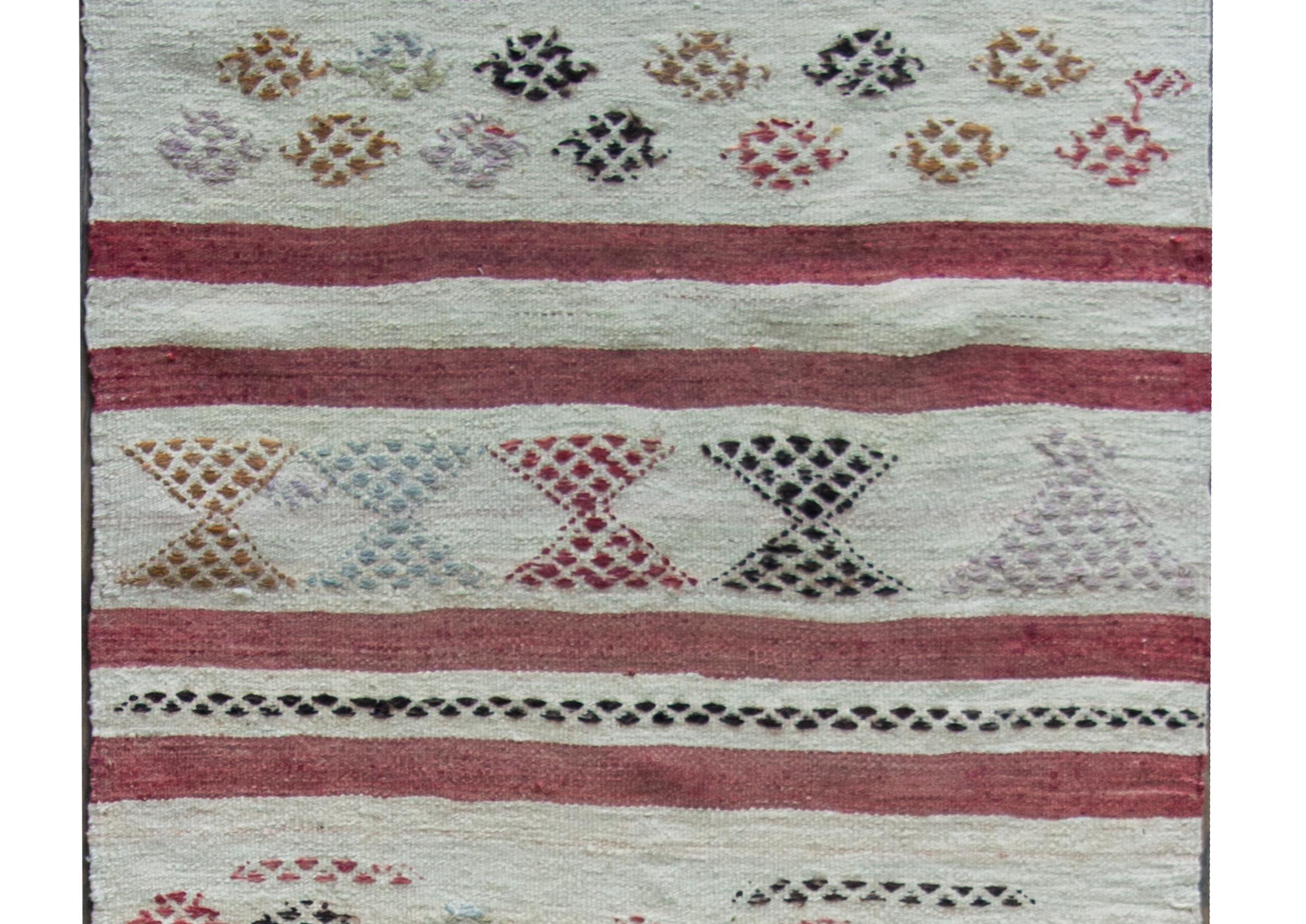 Precioso kilim turco de Konya de mediados del siglo XX con rayas rojas y blancas repetidas, y con rombos multicolores bordados a lo largo de las rayas blancas.