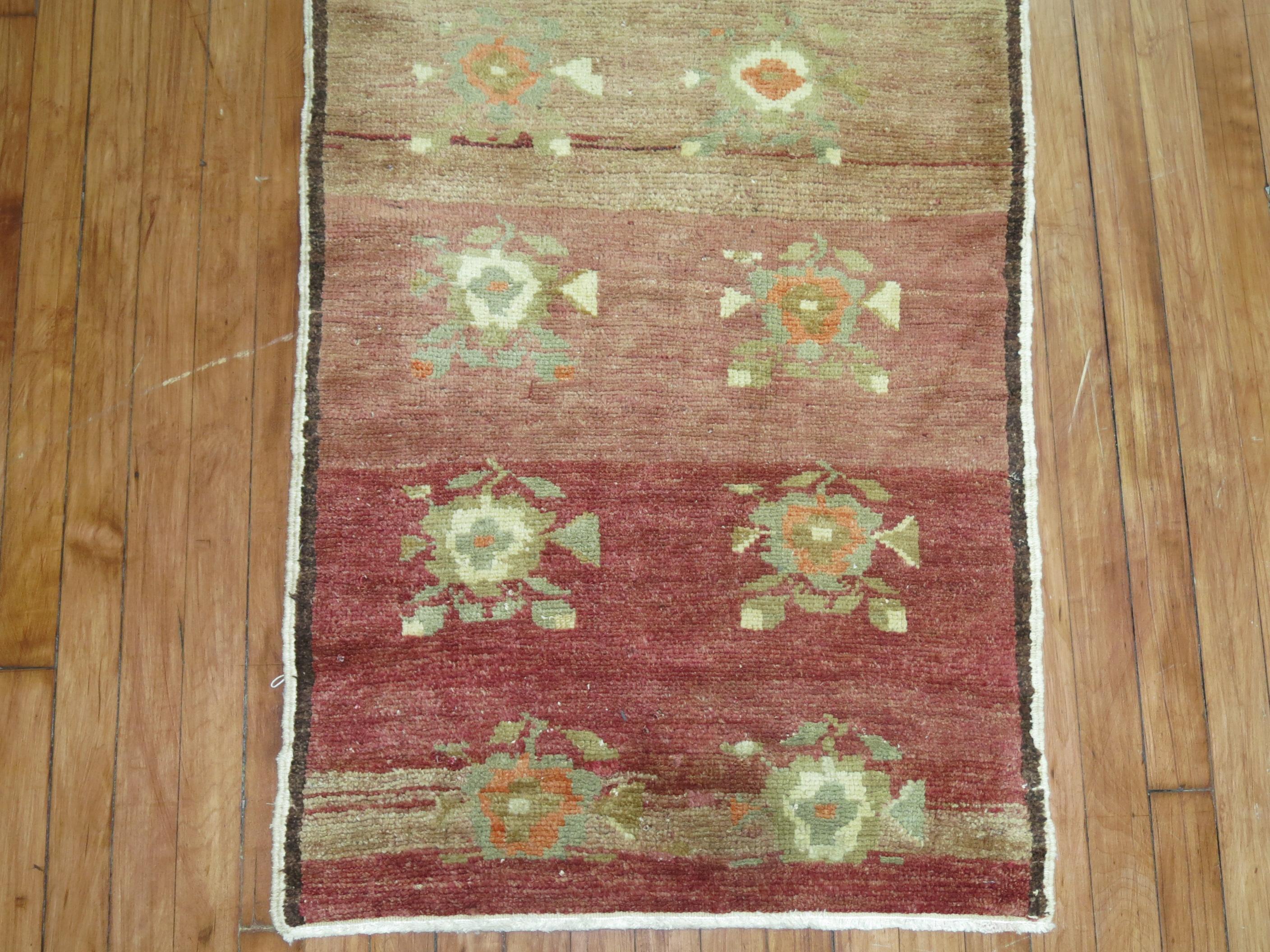 One of a Kind Vintage Turkish Konya runner from the middle of the 20th century. A floral design on a muted red abrashed field