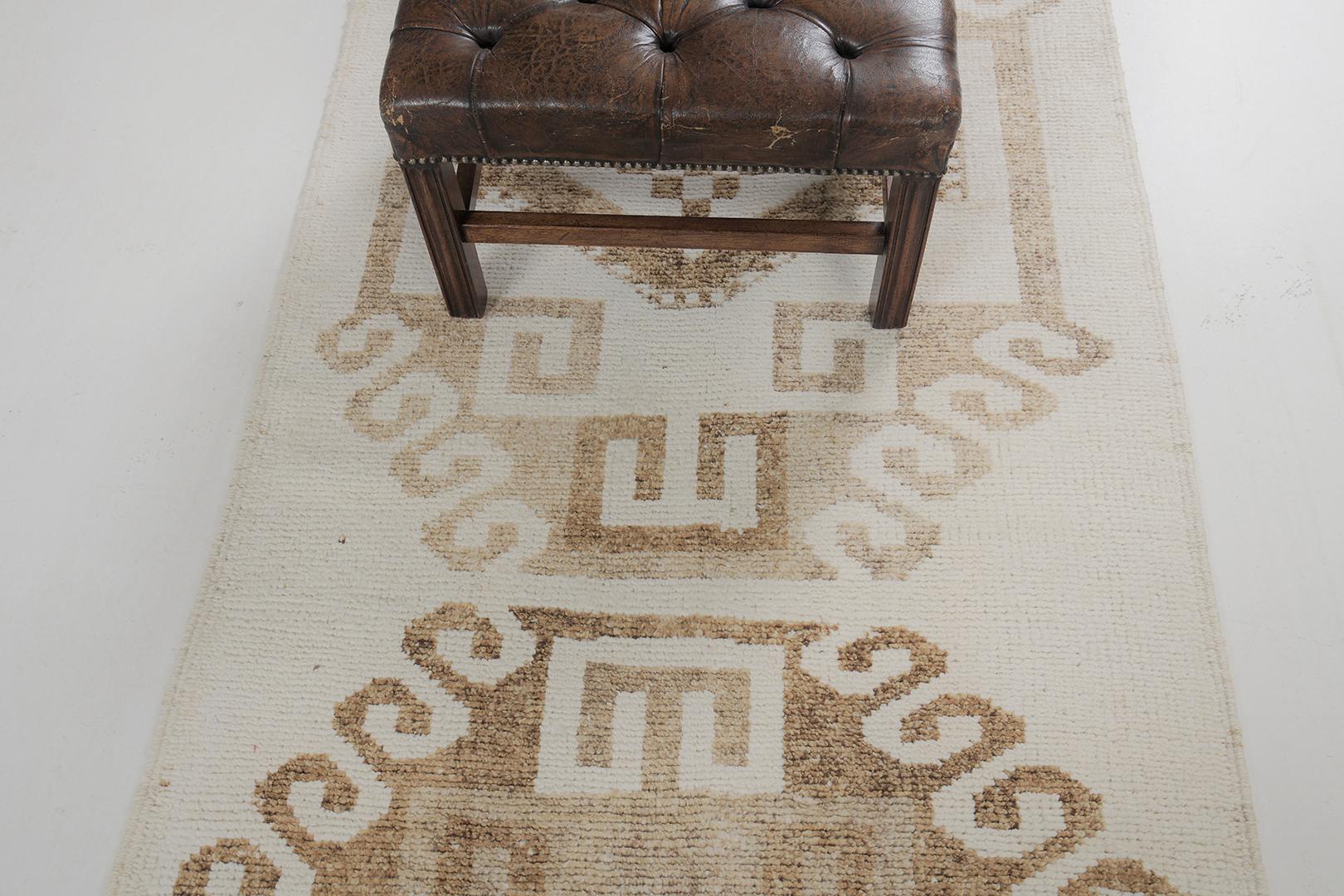 Emanating sophistication and finesse, this vintage Turkish Kurdish runner provides an elegant and impressive aesthetic design in warm subtle hues. Series of medallions anchored with delicate gul and diamonds floats in an abrashed cream field. The