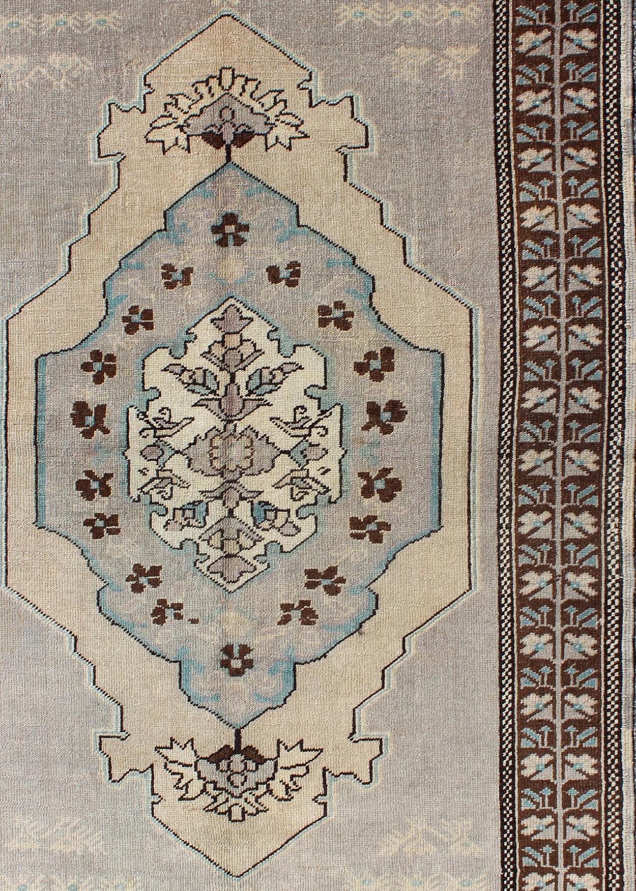 Vintage Turkish Medallion Oushak Area Rug in Gray, Taupe, Brown and Cream

This piece was hand-knotted in the mid-century in Turkey. The field displays a diamond medallion decorated with floral motifs. The field is rendered in cool shades of light