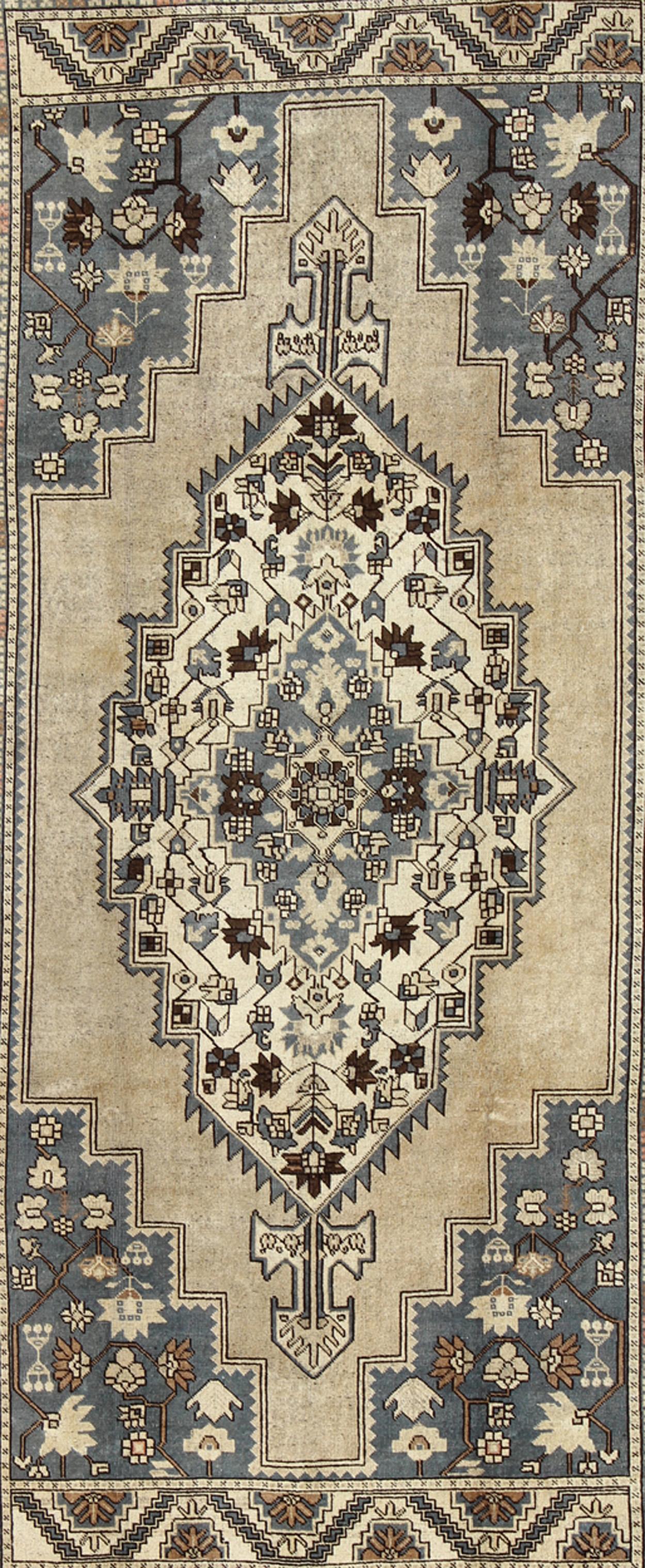 Medidas: 7'2 x 12'9

Único en su paleta de colores y composición, este Oushak vintage presenta motivos a gran escala y un medallón central. El diseño del campo se presenta en azul turbio, topo arena, marrón chocolate y crema. El borde de banda