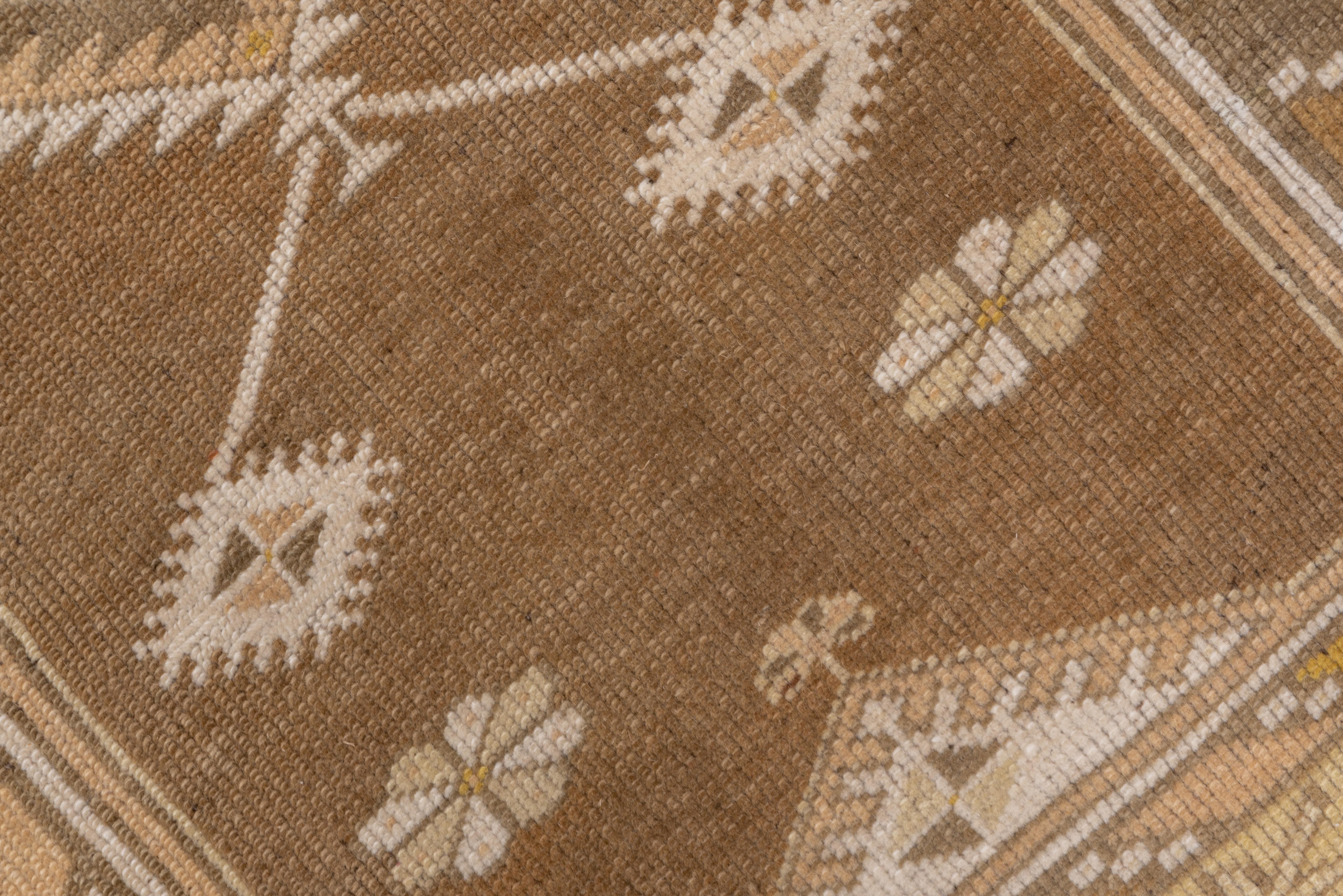 A Classic 20th century Melas rug in a prayer design with a pinched rust field with small and large serrated lozenge designs, ivory tree spandrel panel and a straw border of serrated hexagons and geometric buds.