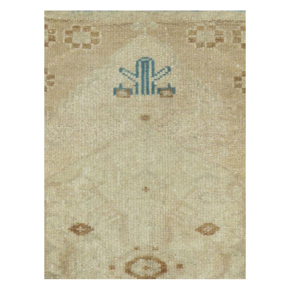 A vintage Turkish Oushak 2' x 3' scatter throw rug handmade during the mid-20th century in shades of beige, brown, and blue-green.

Measures: 2' 1