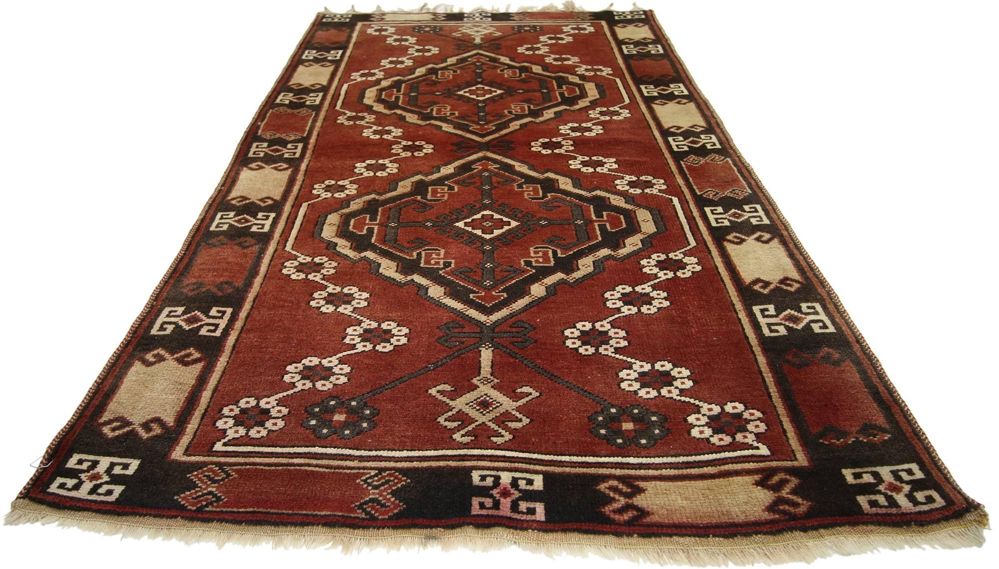 74500, ein alter Oushak-Teppich mit Stammesmotiv. Dieser alte türkische Oushak-Teppich aus handgeknüpfter Wolle zeigt doppelte Amulette mit geometrischen Mustern auf einem Feld in rustikalem Ziegelrot. Die Amulette bestehen aus miteinander