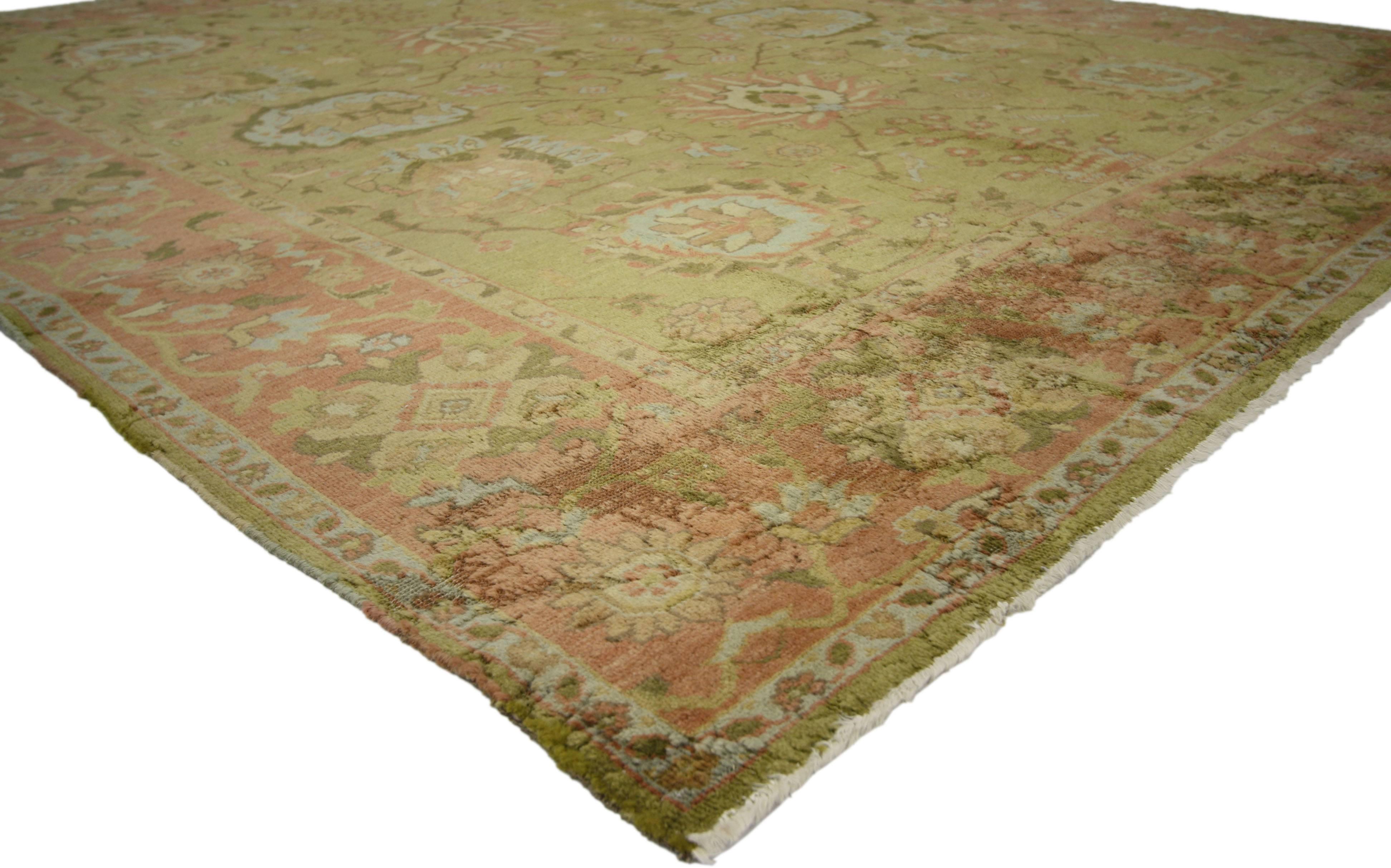 76688, a vintage Turkish Oushak area rug. This gorgeous hand-knotted wool Turkish Oushak rug features a classic vase design and blooming lotus in pistachio and cerulean; palmettes of salmon, cream and sage and corner palmettes in a similar color