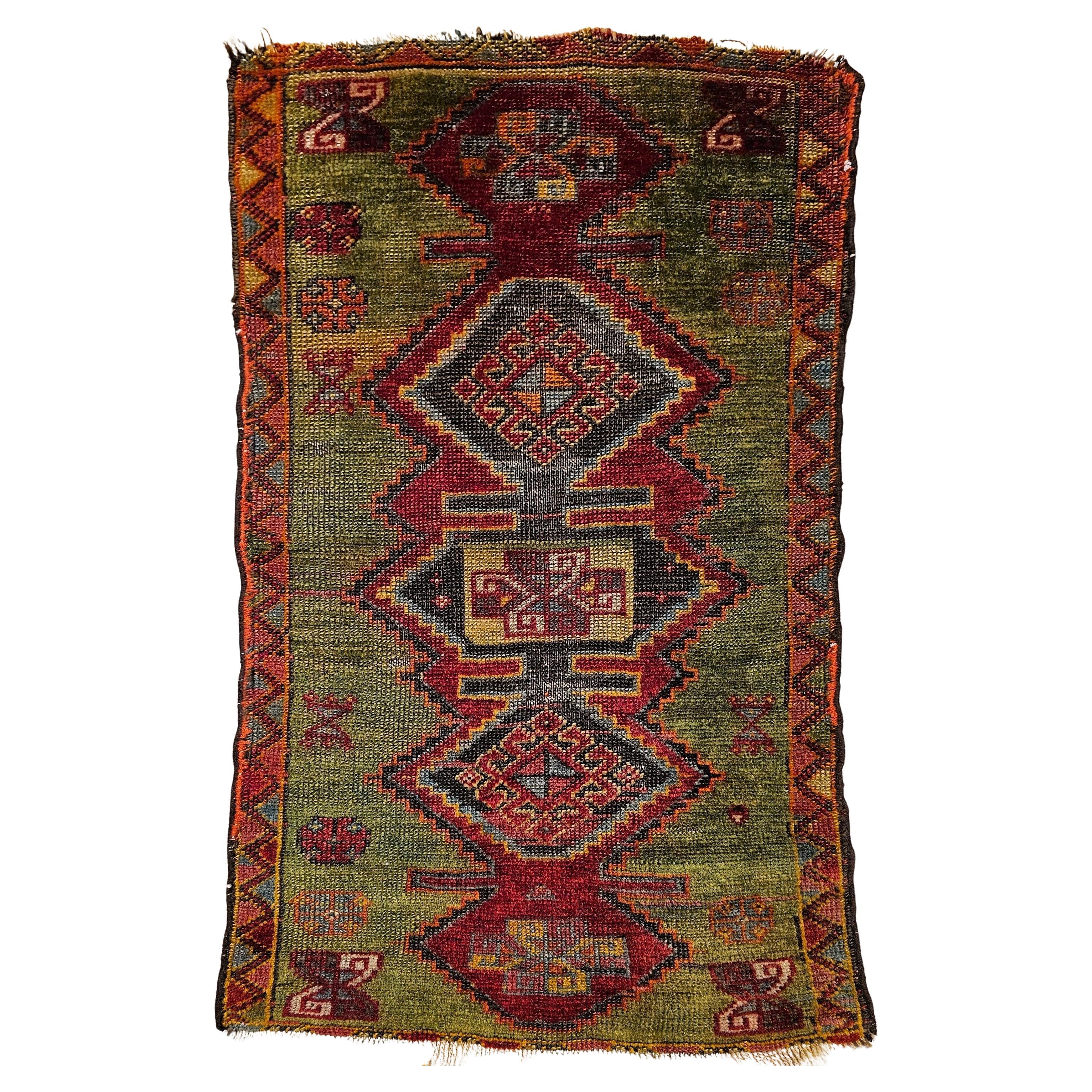 Tappeto vintage turco Oushak con motivo geometrico in verde, giallo e rosso in vendita