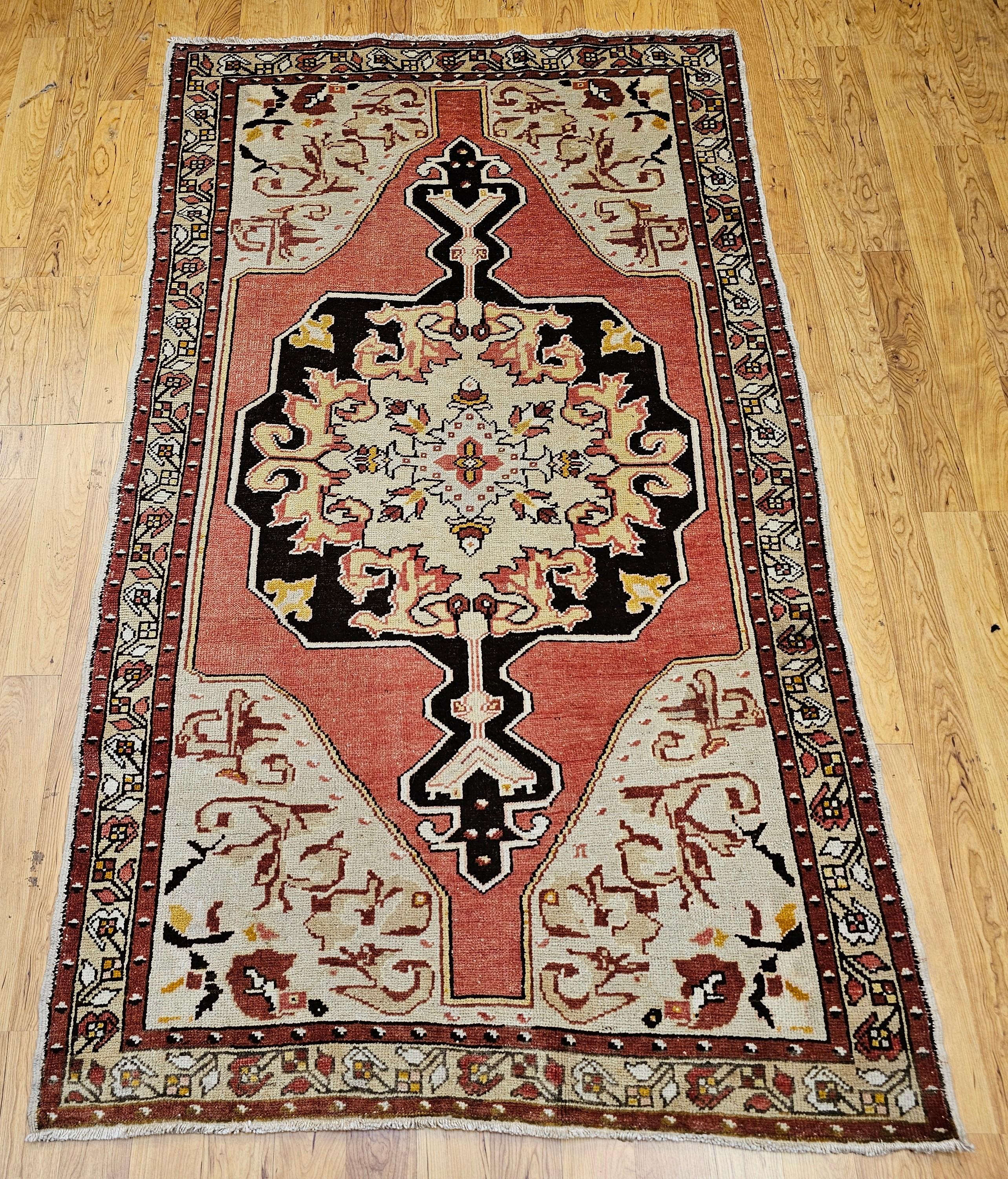 Dieser exquisite türkische Oushak-Teppich, der Anfang 1900 handgewebt wurde, ist ein Beispiel für die Eleganz und weiche Raffinesse anatolischer Webtraditionen. Vor einem warmen cremefarbenen Hintergrund umgibt ein leuchtendes, blassrosa Medaillon