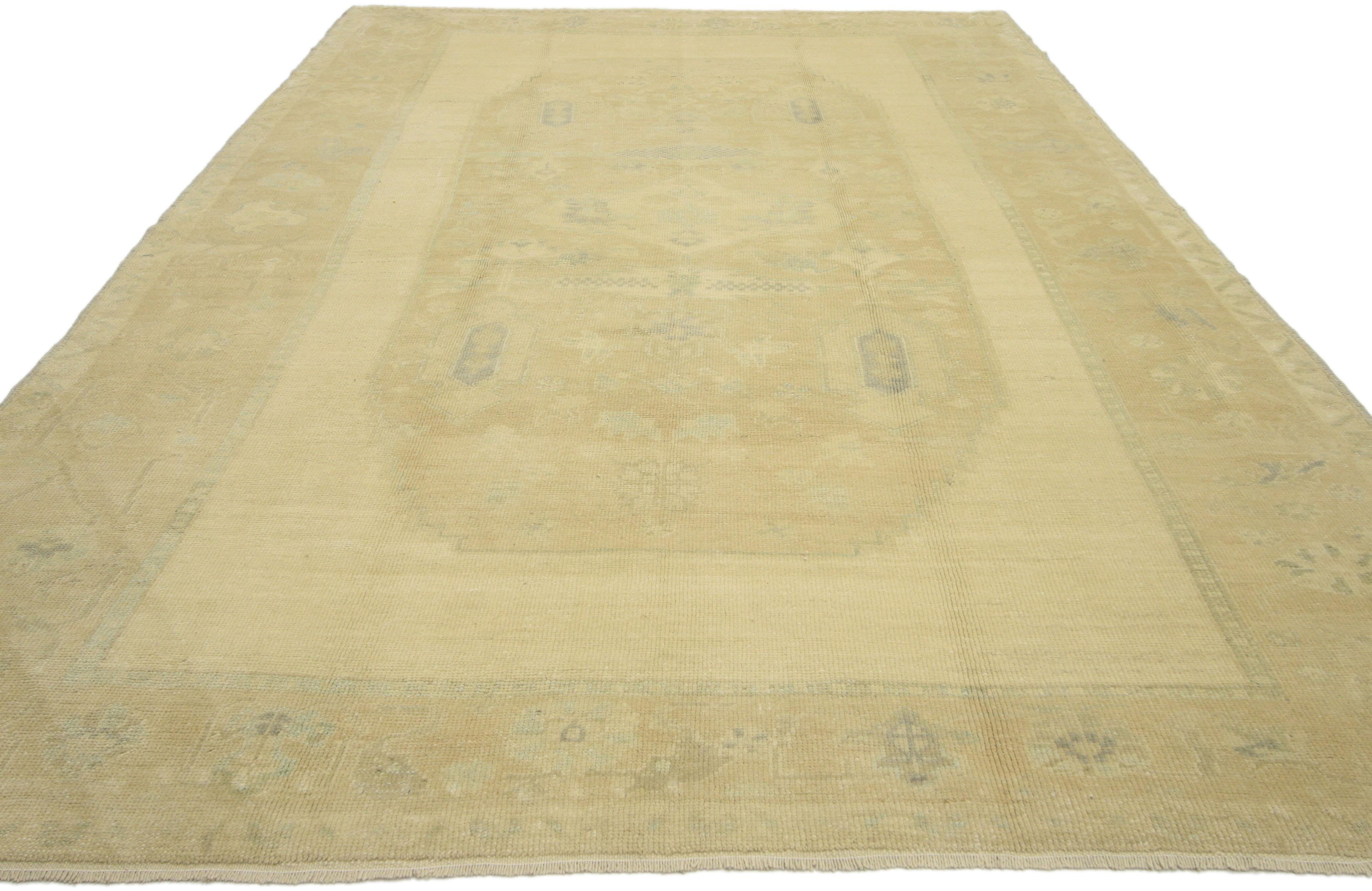 51343, tappeto vintage turco Oushak con colori tenui e sbiaditi. Questo tappeto vintage turco Oushak in lana annodato a mano presenta un grande medaglione a gradini con una serie di palmette in fiore, motivi geometrici e fiori stilizzati. Il grande
