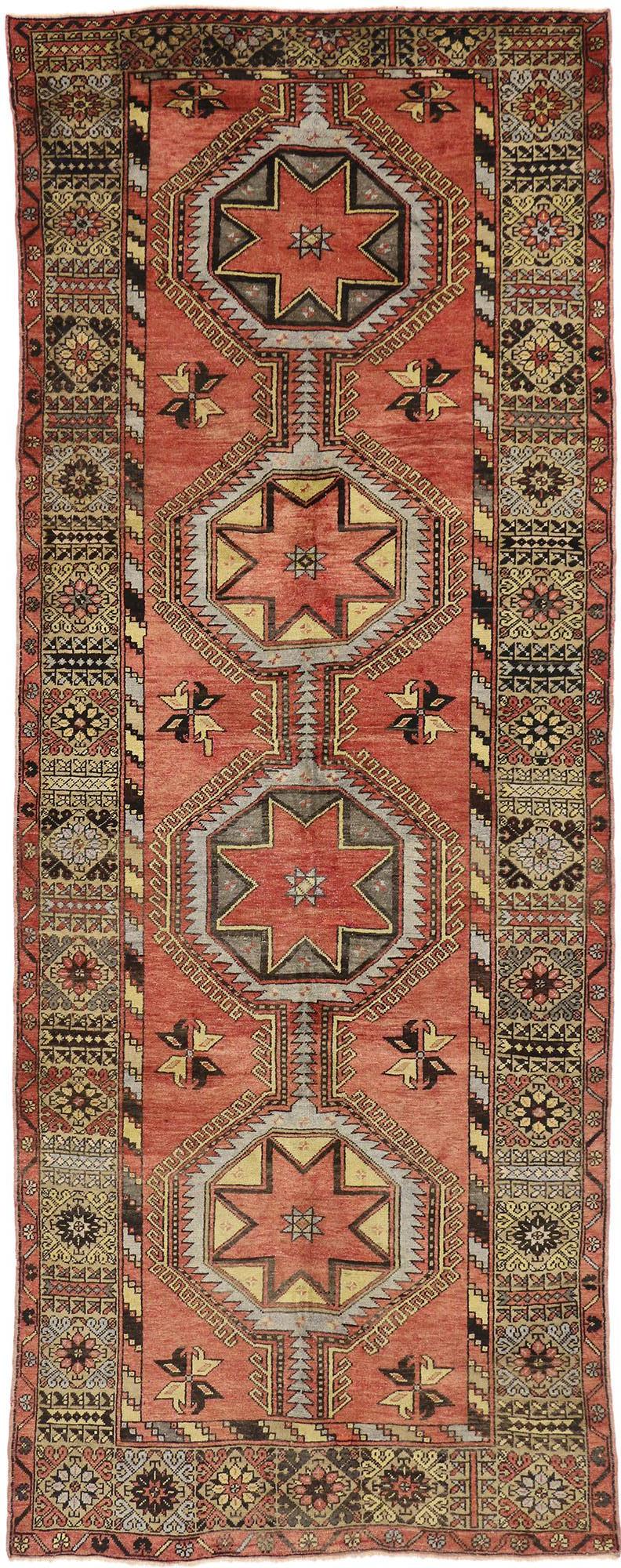 This vintage Turkish Oushak carpet runner with modern tribal style communicates some of the finer and more important points of traditional Turkish design elements. Features a stacked row of eight-point Oushak star medallions surrounded by tribal