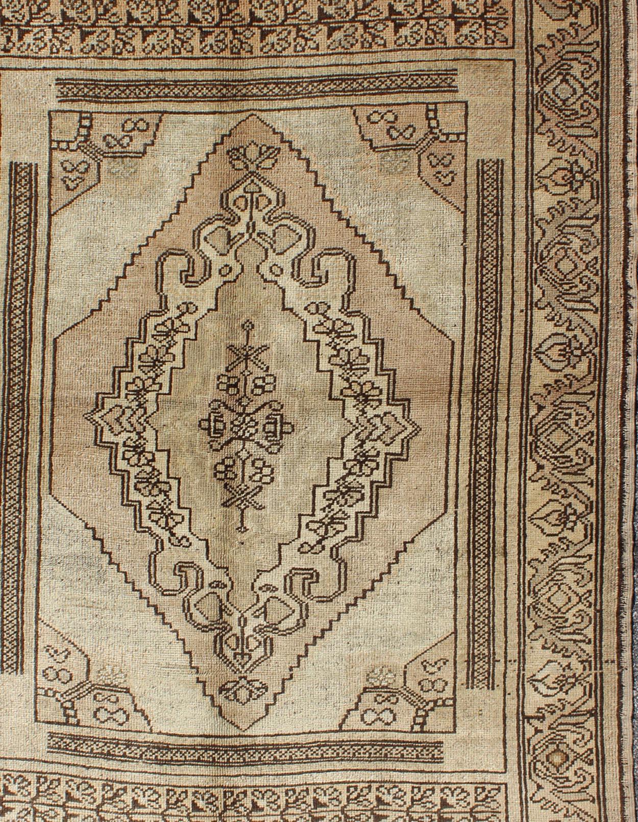 Measures 4 x 5'7

This oushak rug features an intricately beautiful design. The central medallion is complemented by a defining border featuring a symmetrical set of geometric floral motifs. The various shades of brown, cream, and tan blend