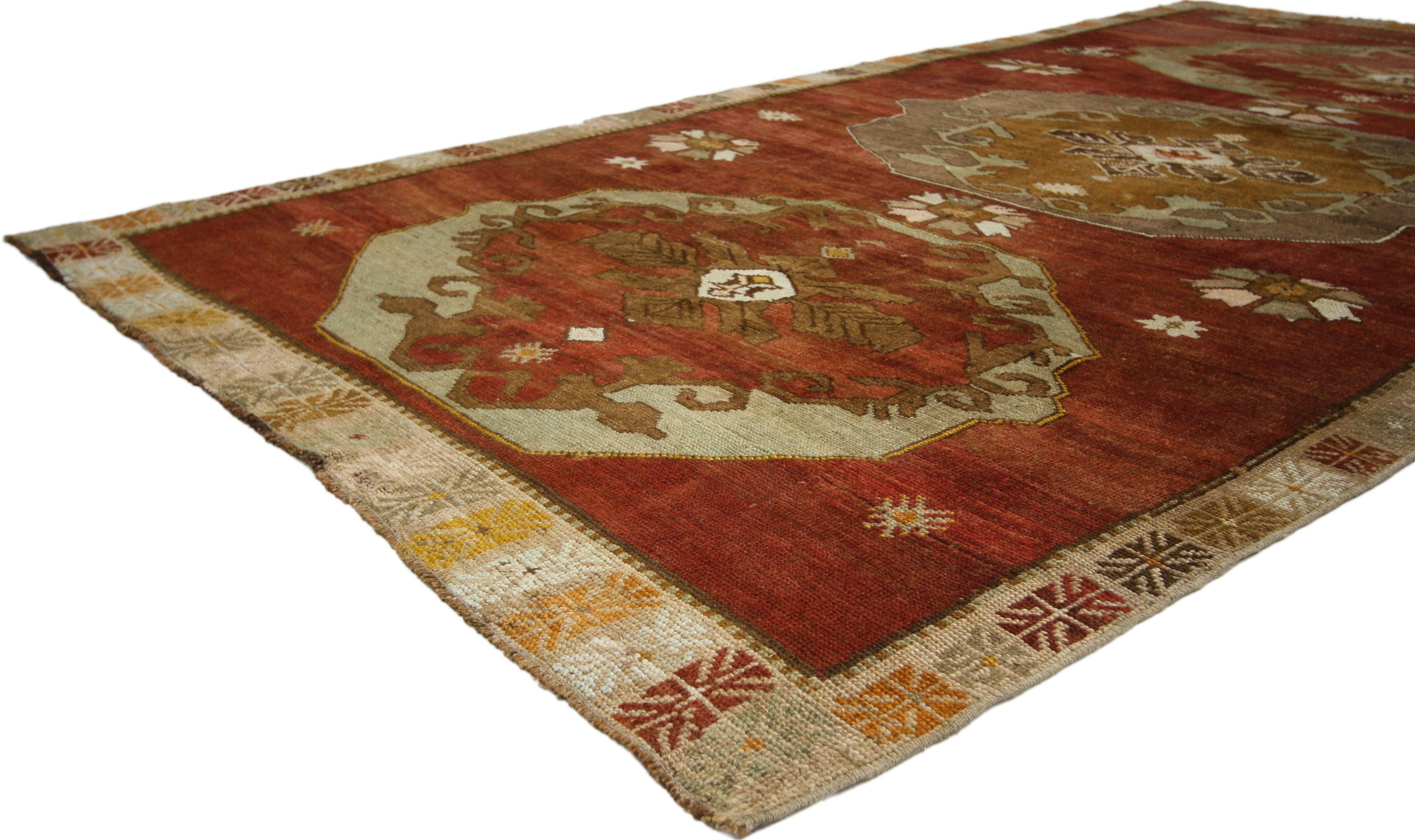 52316, tapis galerie turc vintage Oushak de style Jacobien ou Tudor. Ce tapis turc Oushak vintage en laine nouée à la main présente trois grands médaillons floraux hexagonaux répartis sur un champ rouge abrasé. Les médaillons contiennent chacun des