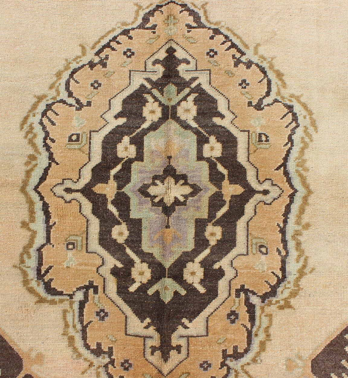 Measures: 4'11 x 10'4. 

This beautiful vintage Oushak gallery rug from mid-20th century Turkey features a Classic Oushak design. The faint sand ground is home to two large and elegant medallions of chocolate brown, yellow, taupe and pale blue. The