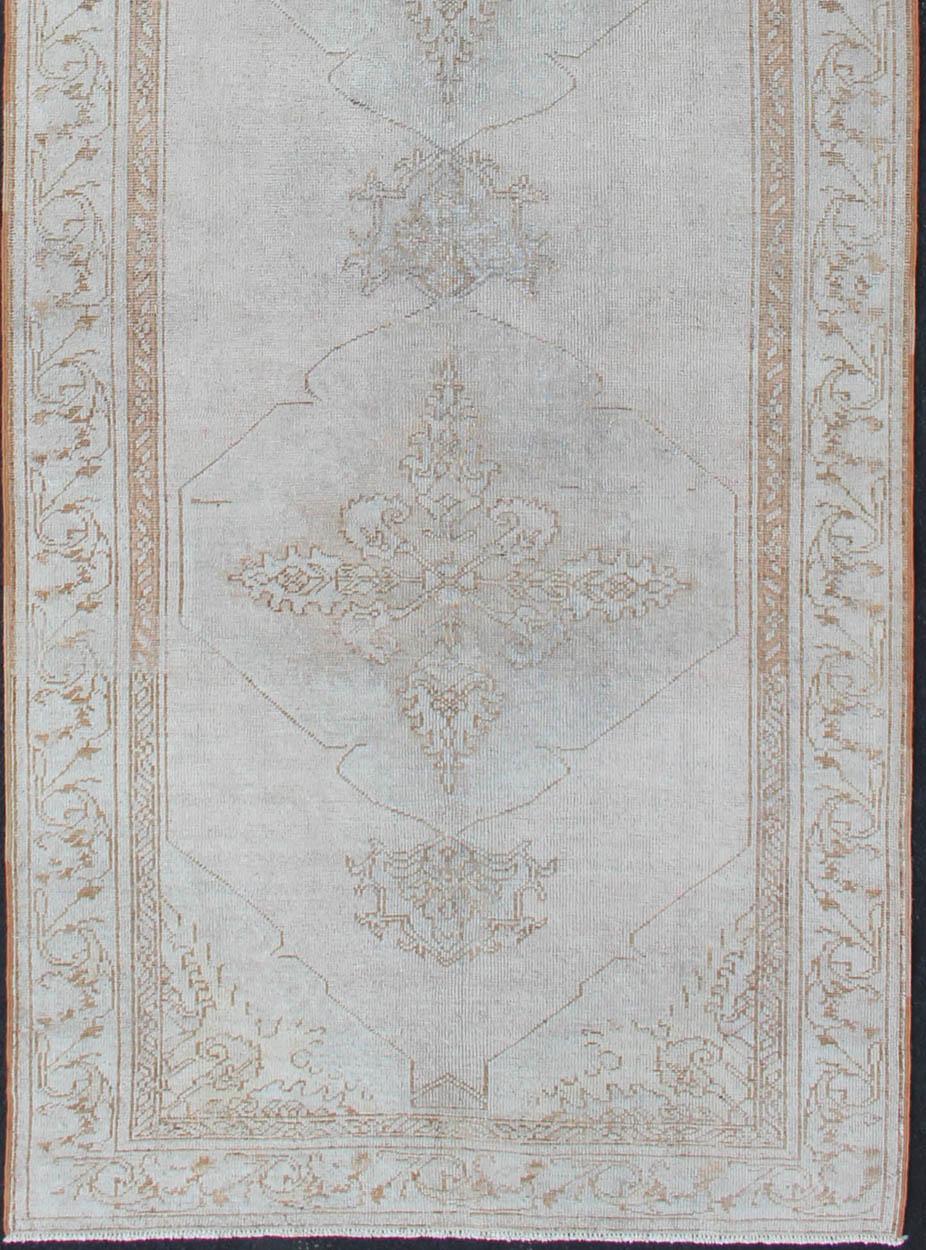 Vintage Turkish Oushak gallery runner with medallions in muted tones, rug na-54280, country of origin / type : Turquie / Oushak, vers le milieu du 20ème siècle

Ce magnifique chemin de table Oushak vintage datant du milieu du 20e siècle en Turquie