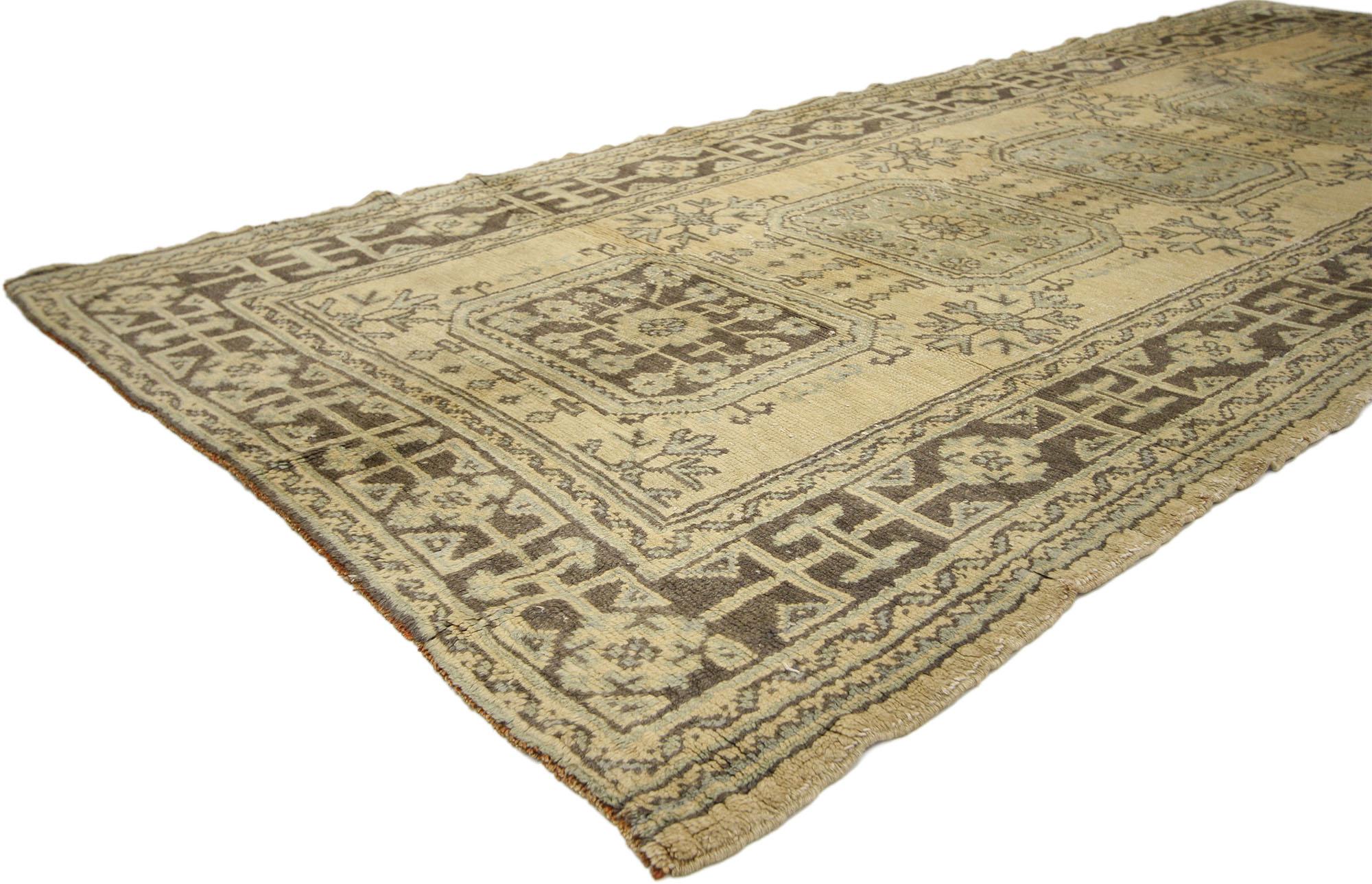 51140, vintage Turkish Oushak hallway runner with Gustavian or French Country style. This hand knotted wool vintage Turkish Oushak runner features five amulet medallions filled with roundels and floral sprays floating on an abrashed ecru field