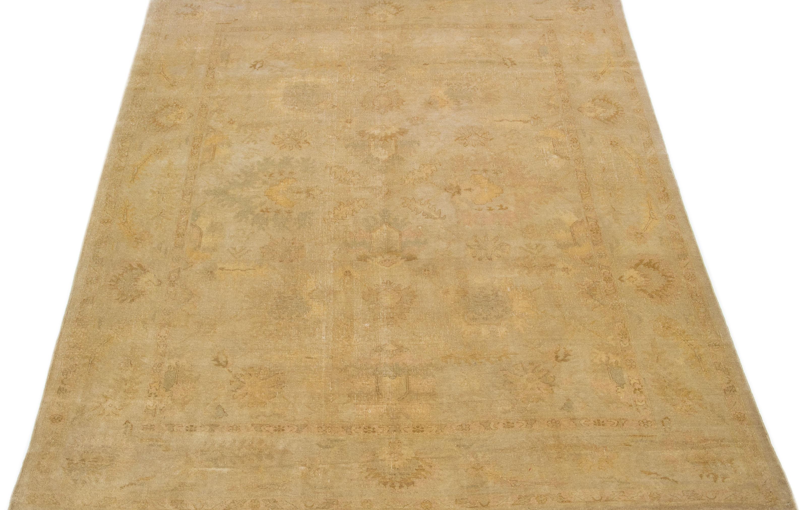 This hand knotted wool rug boasts a stunning Vintage Oushak design, featuring an elegant beige field complemented by Classic floral patterns in shades of brown and tan. 

This rug measures 8'10